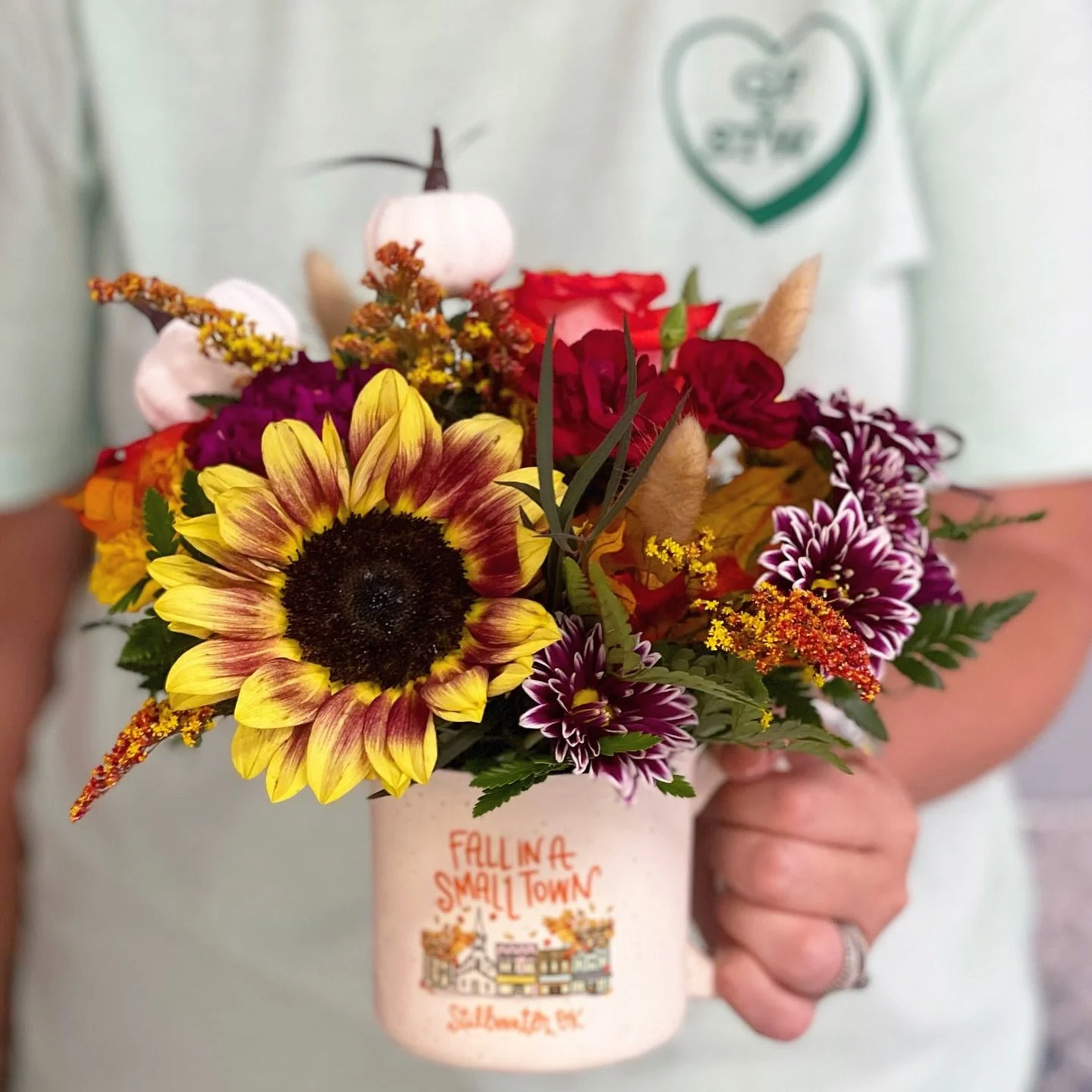 Our Fall in A Small Town arrangement comes tucked inside a custom ceramic Stillwater mug. 🌻☕️ The blooms bring all the autumn color now, and the mug sticks around for coffee, tea, or a little hometown pride long after. 🍁🍂 Limited mugs available &m