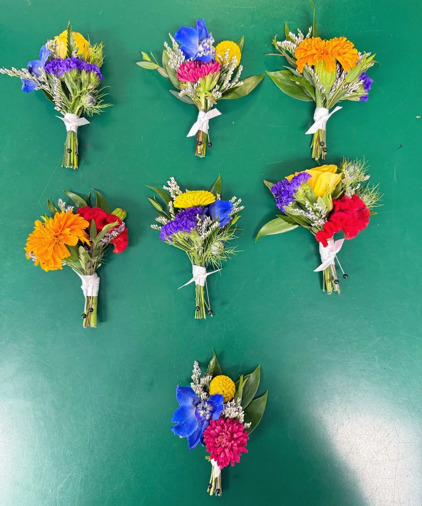 Who says boutonnieres have to match perfectly? 🌿🌻 Our wildflower versions are colorful, lively, and each one a little different - just like the love they celebrate. 💕