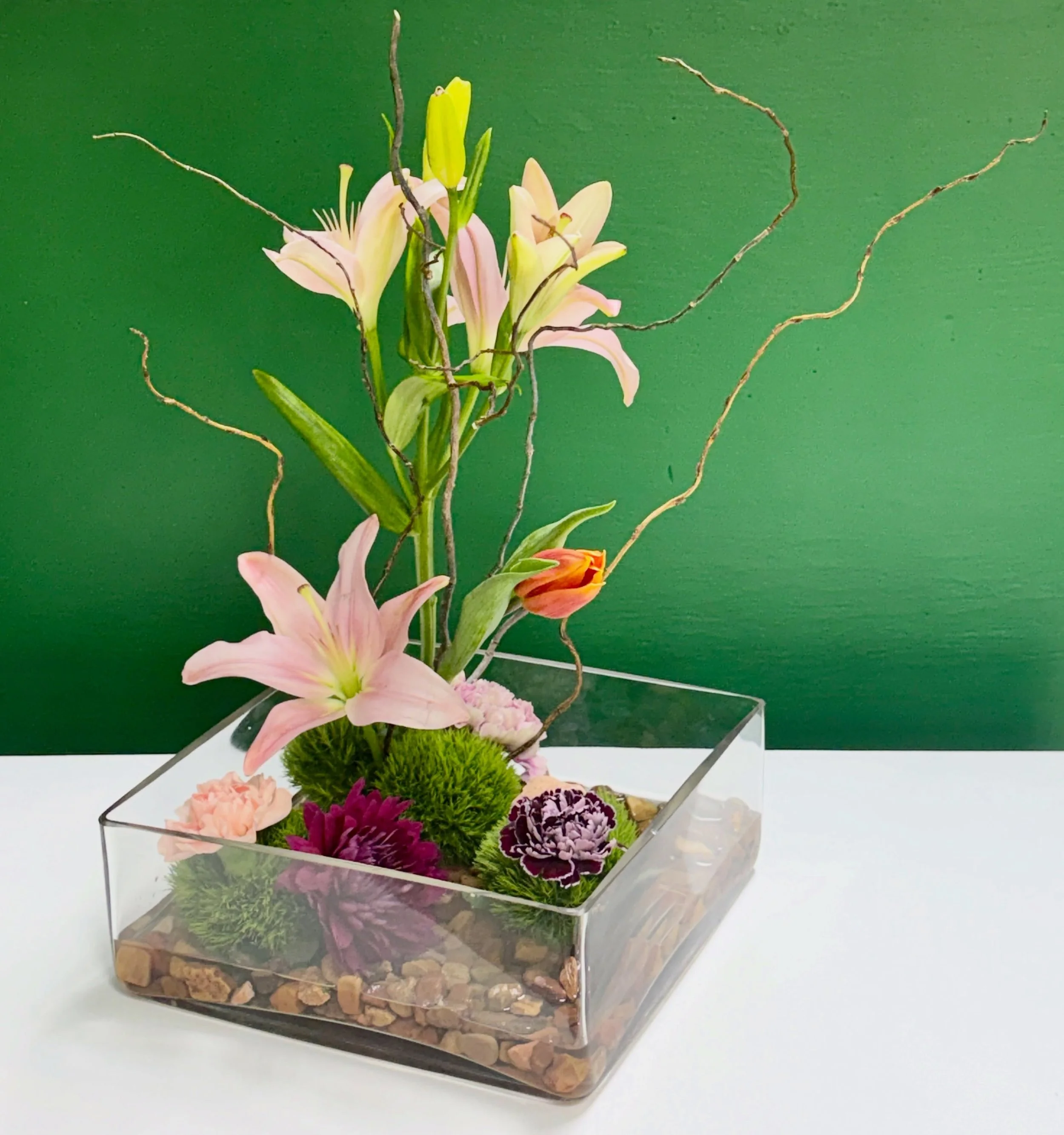 The Space Between - Inspired by the art of ikebana, this sculptural arrangement celebrates graceful lines, natural movement, and the beauty of intentional simplicity. Sometimes the most beautiful part of a design isn&rsquo;t the flowers&mdash;it&rsqu