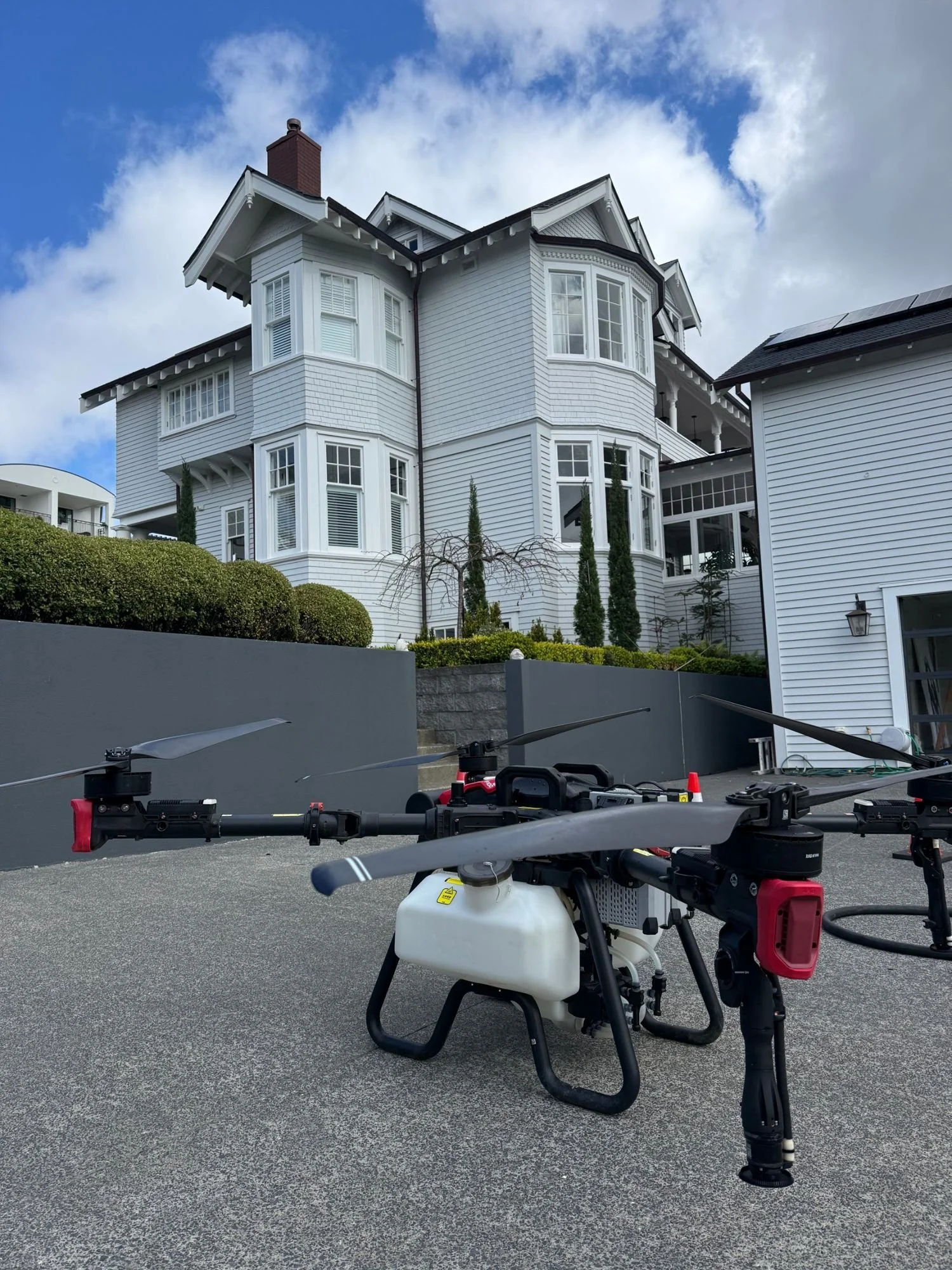 AeroSpray drone spraying treatment onto a house roof