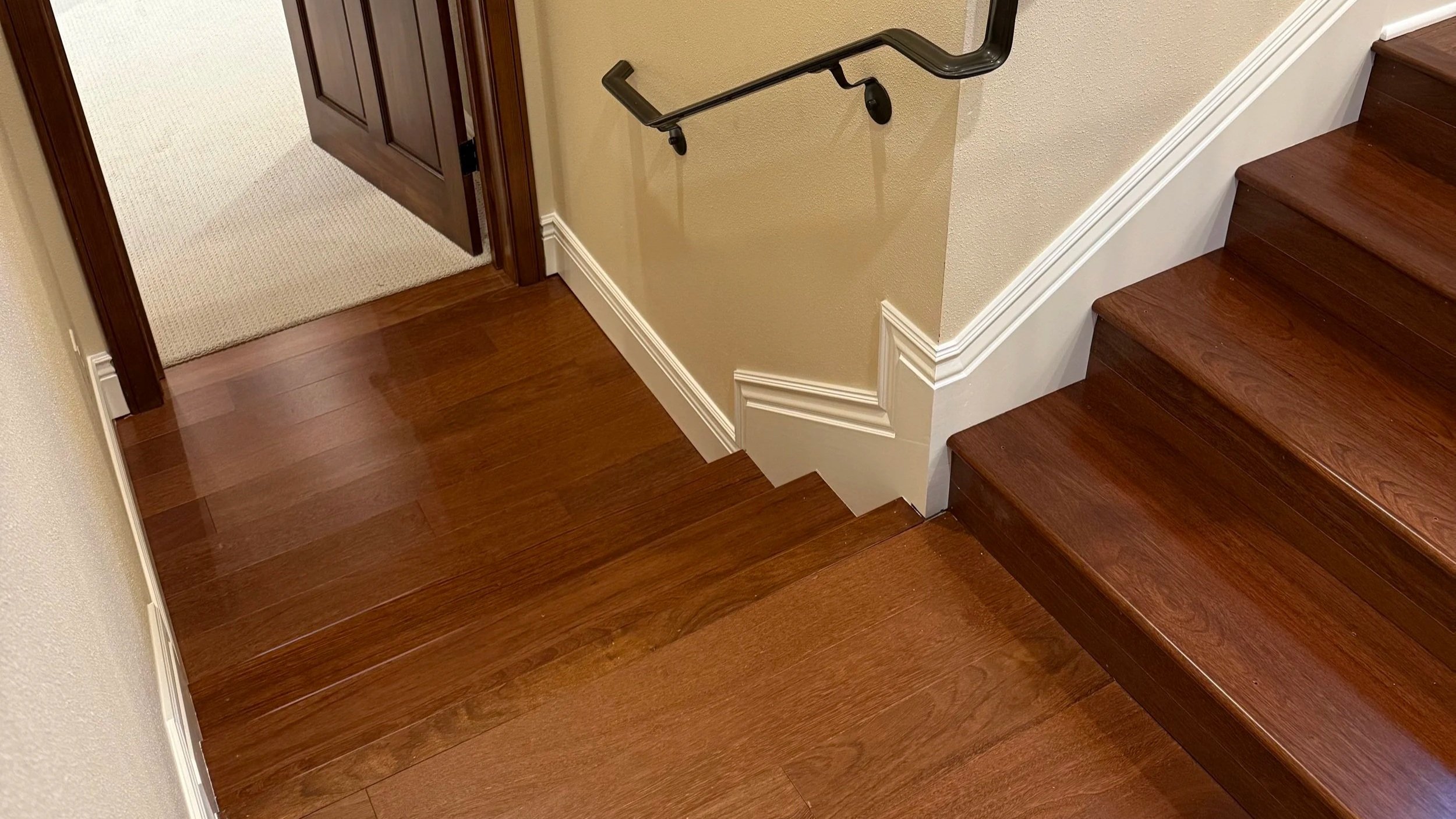 Indoor staircase with marble steps, wooden or marble handrail, and beige walls.
