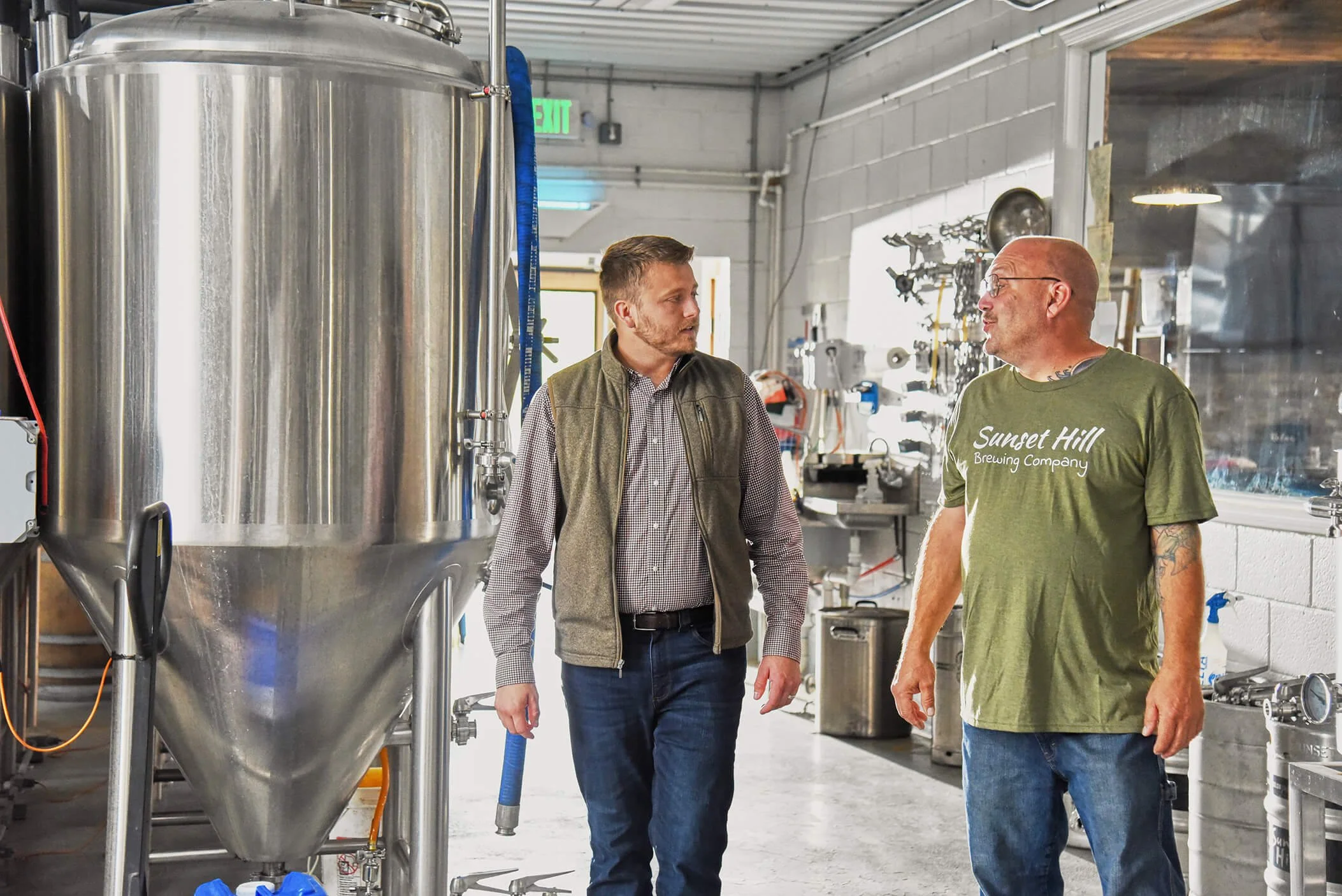 Chris talking to a man inside a brewery.