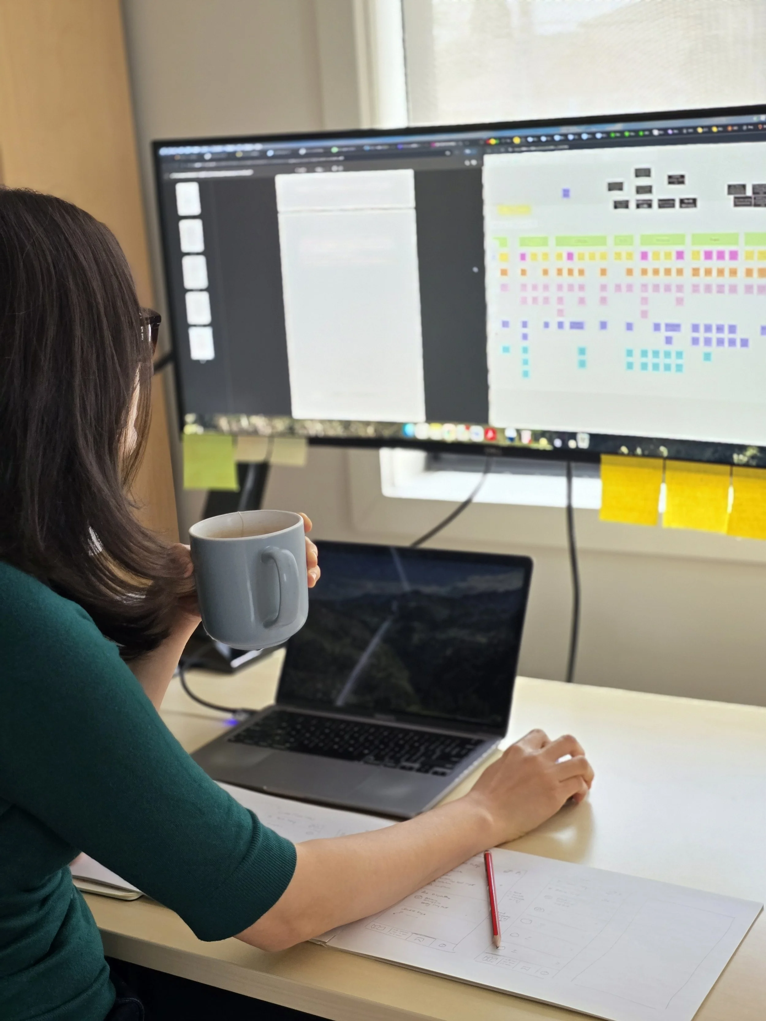Researcher reviewing synthesis notes and documents on a computer