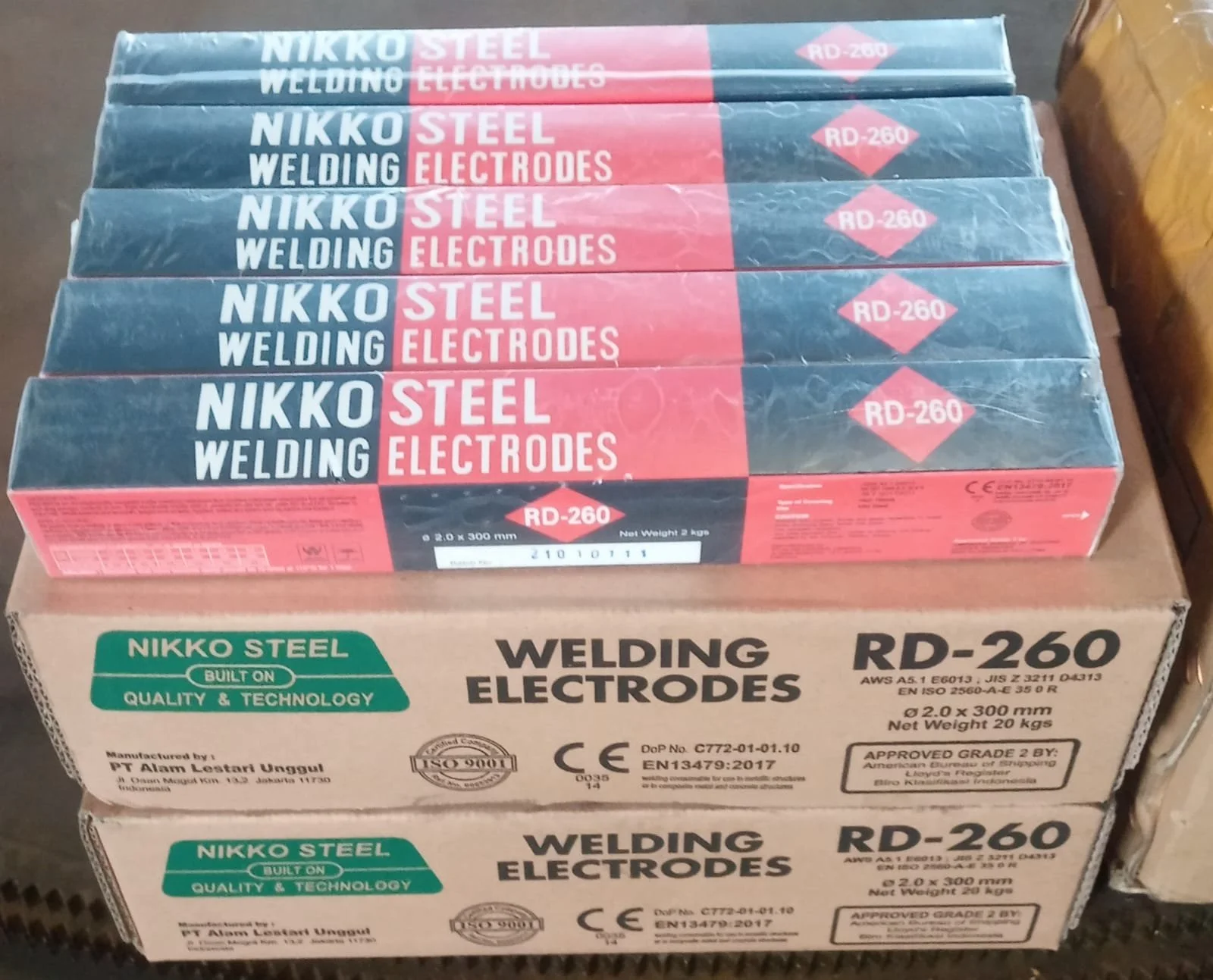 Boxes of Nikko steel welding electrodes, model RD-260, stacked on a table.