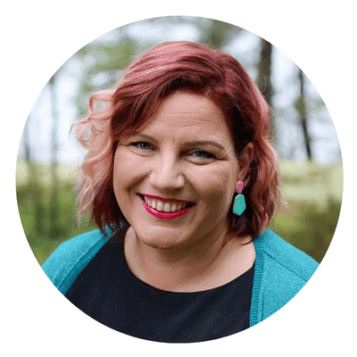 punahiuksinen hymyilevä nainen katsoo kameraan