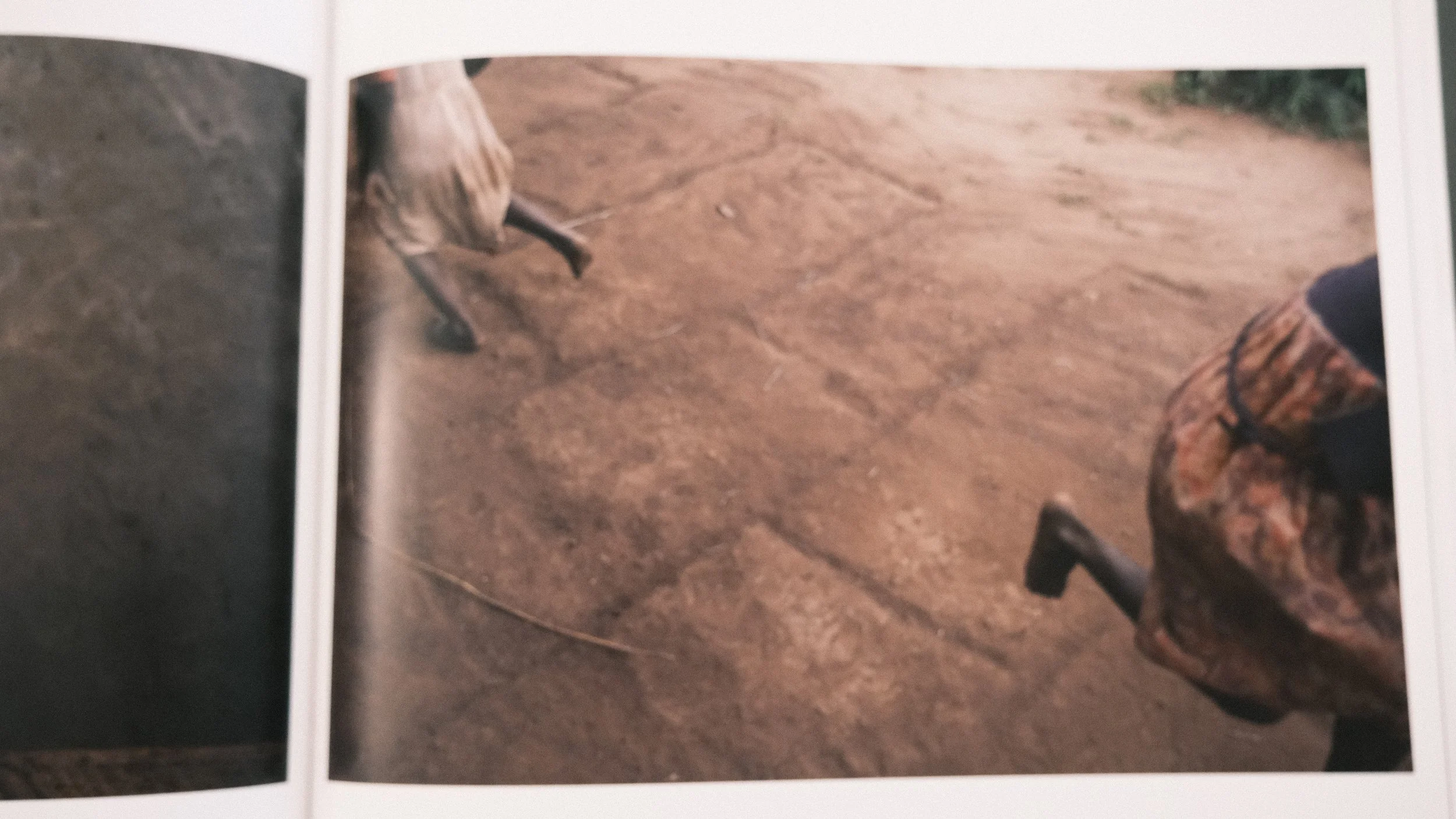 Close-up of two people riding horses on a dirt path, one wearing patterned pants and the other with visible horse hooves.