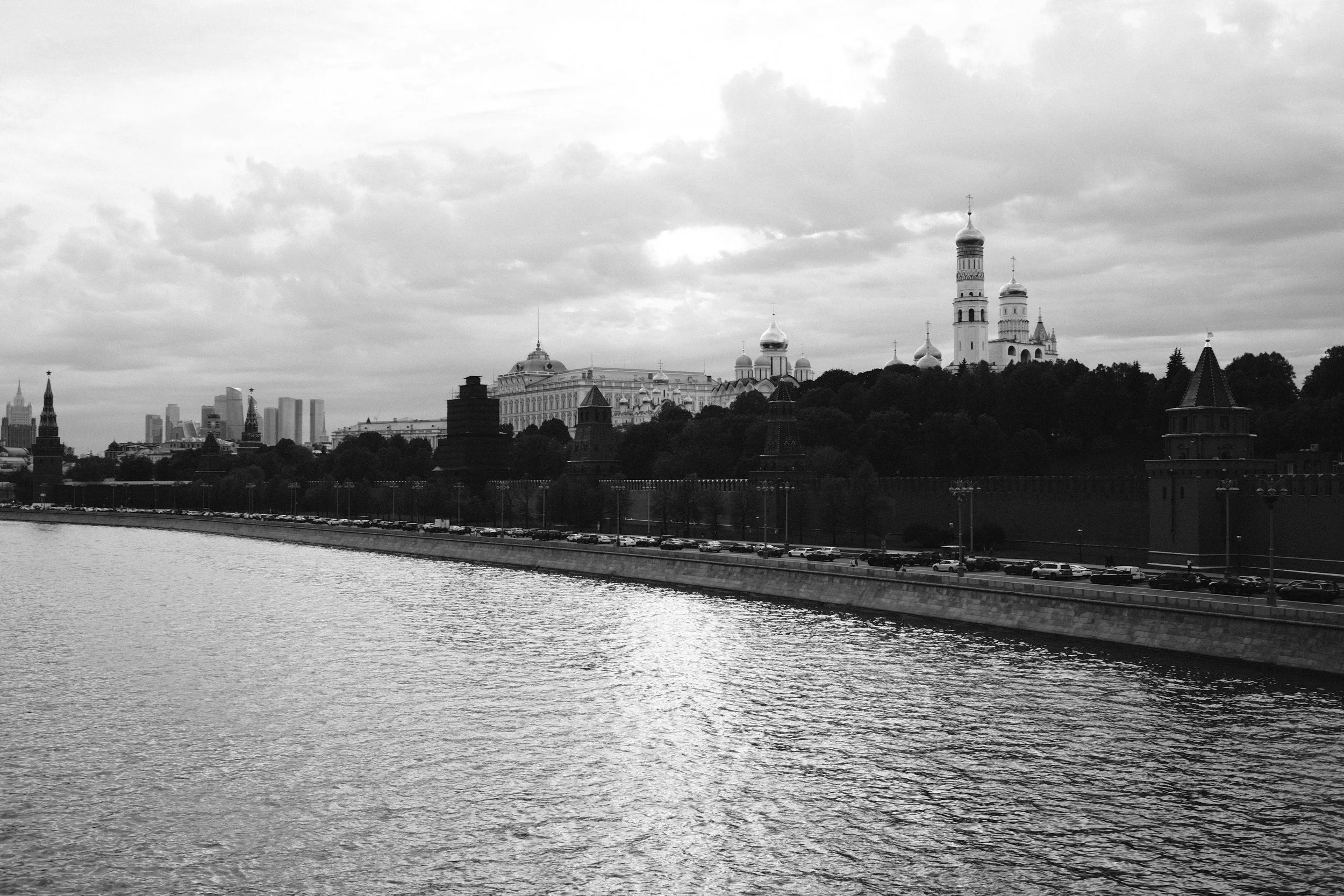 Black and white photo of the Moscow skyline with the Kremlin, river, and city buildings in the background.