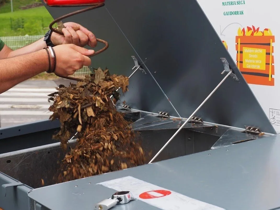 Un brass'compost en train de mélanger du compost
