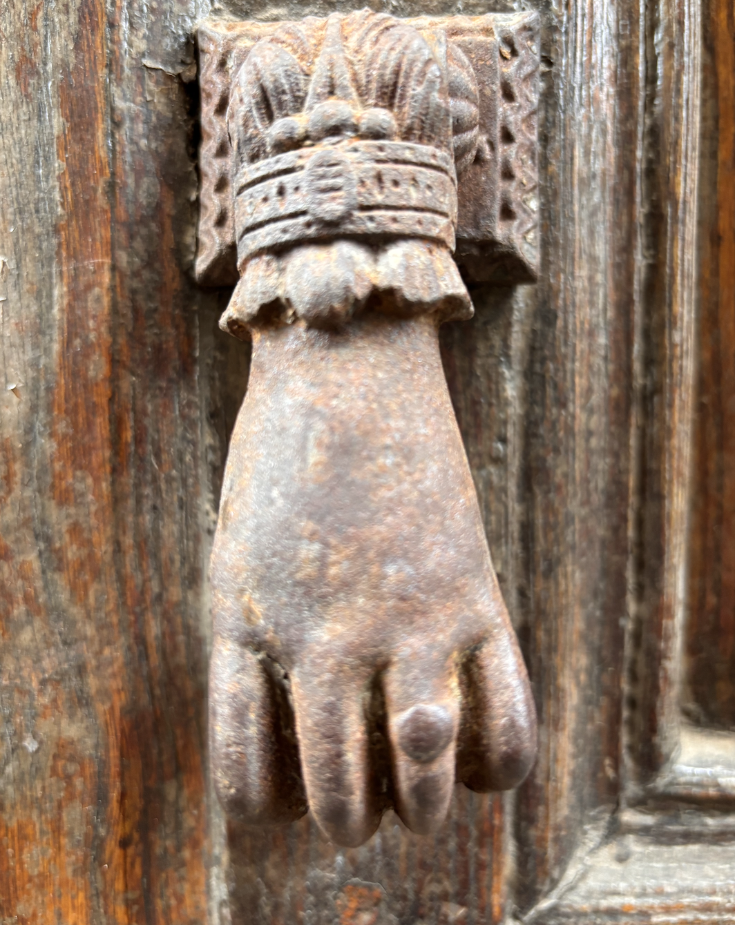 Hand in bronze at a door in Spigno Monferrato