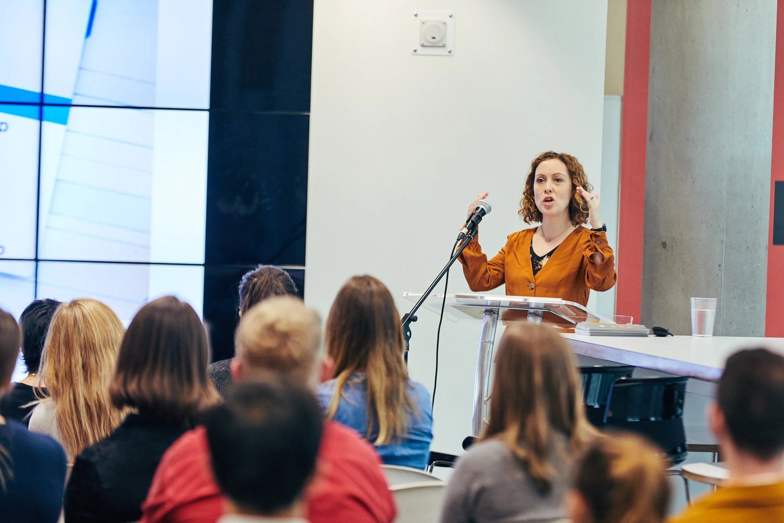Laura Willis speaking to a room of people at a conference