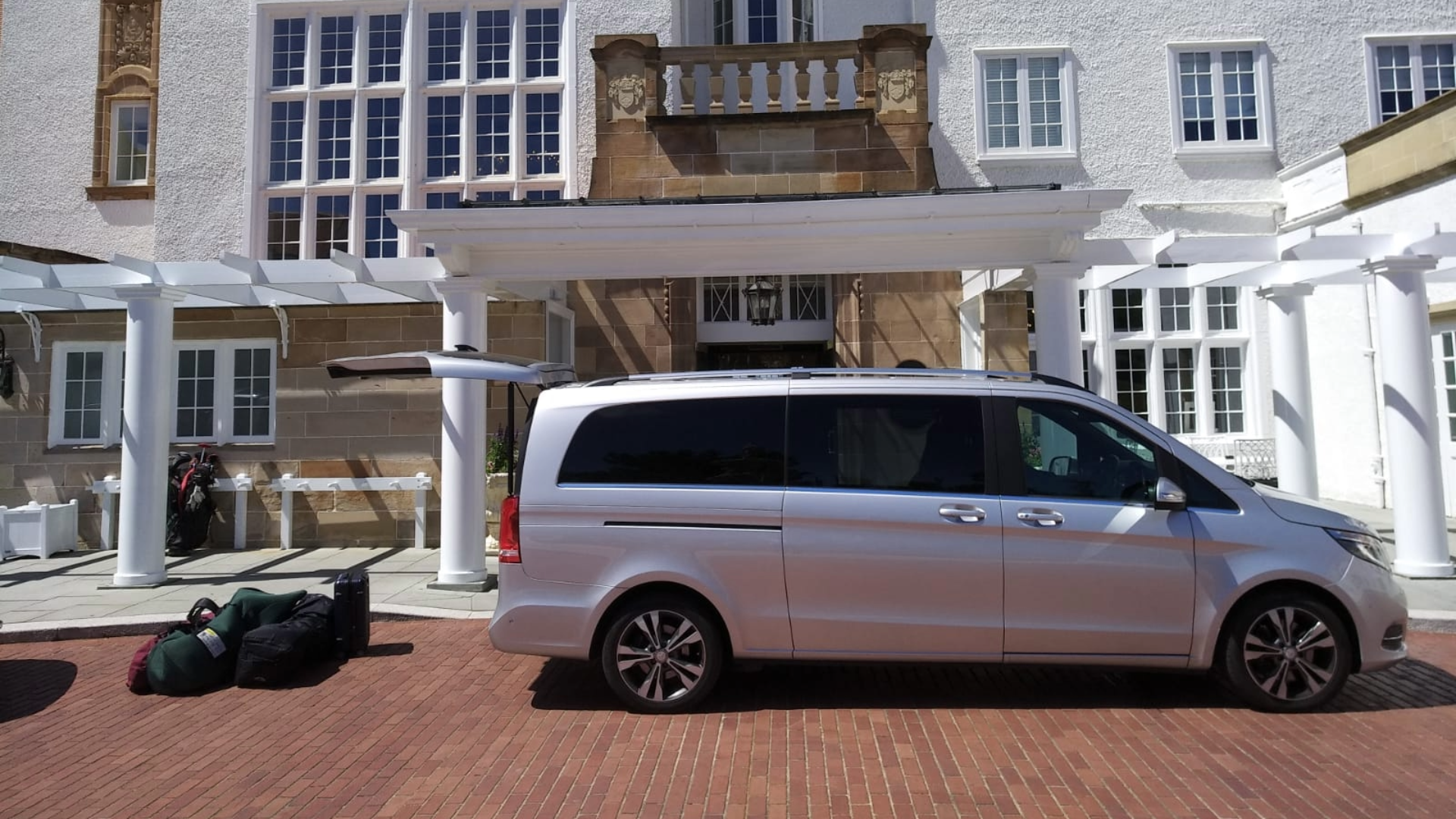 Mercedes-Benz V-Class outside hotel collecting passengers and putting bags into boot
