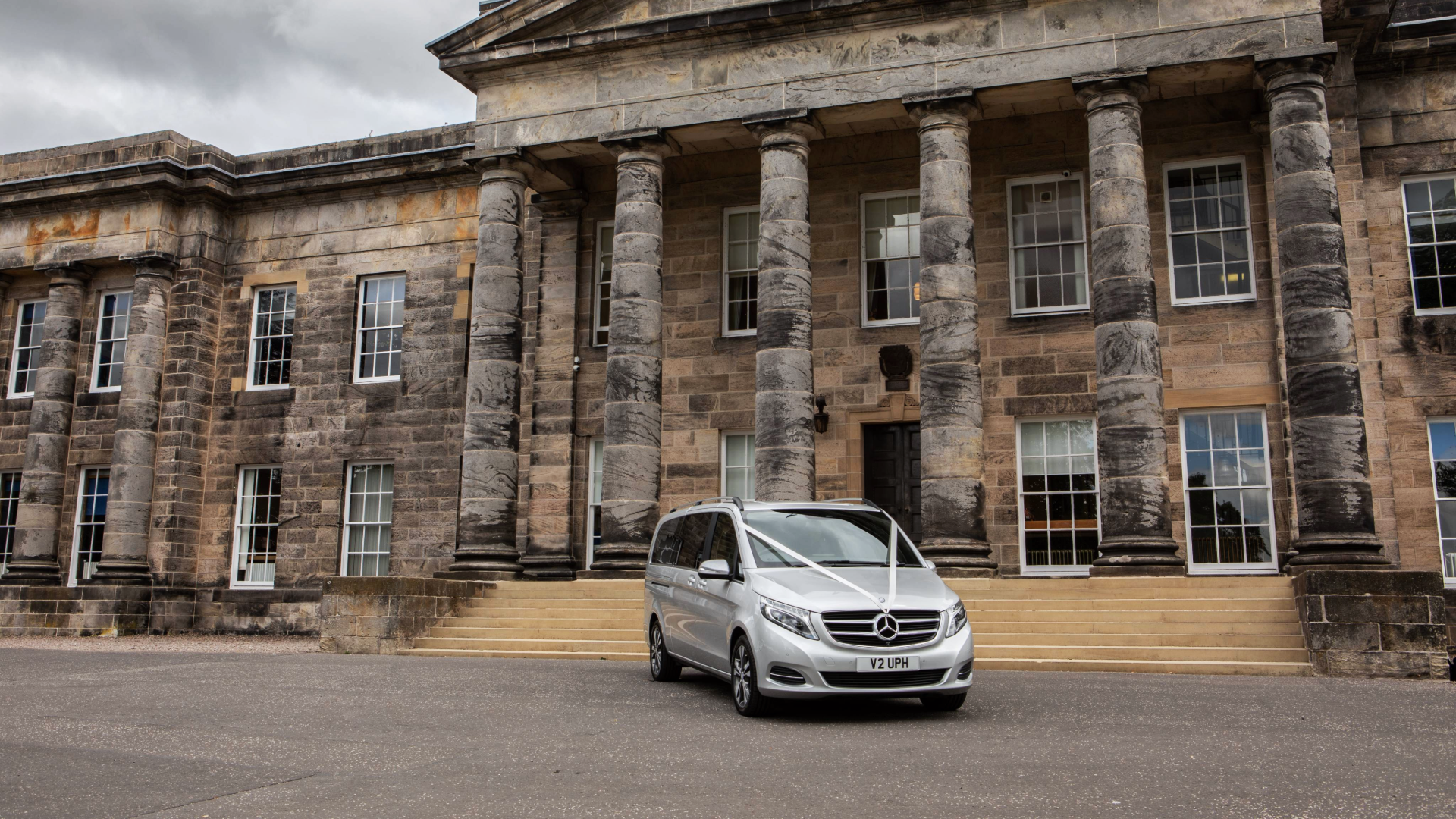 Mercedes-Benz V-Class with ribbon sitting outside event venue