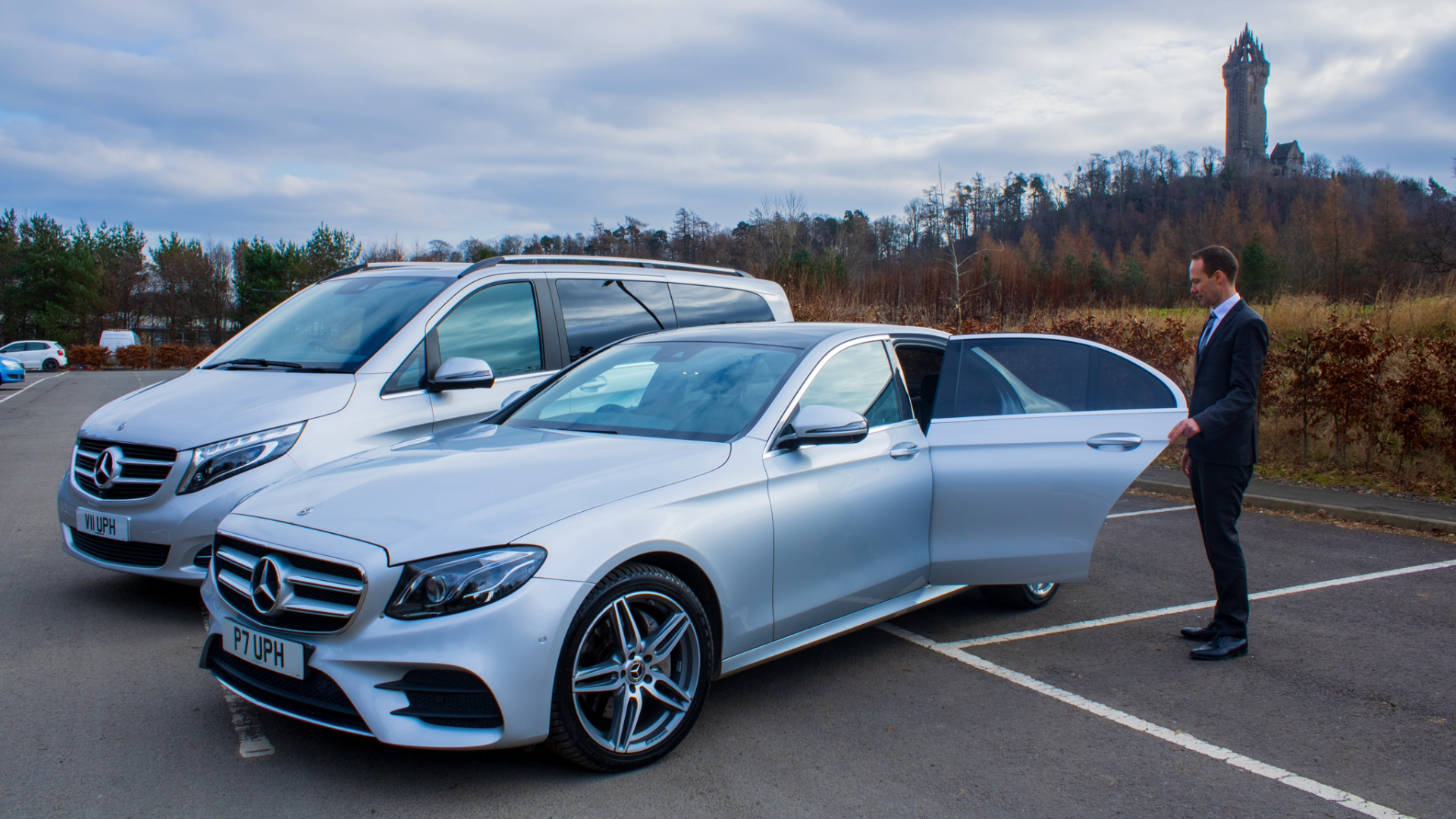 Mercedes-Benz E-Class and V-Class with chauffeur driver opening door with the wallace monument in the background