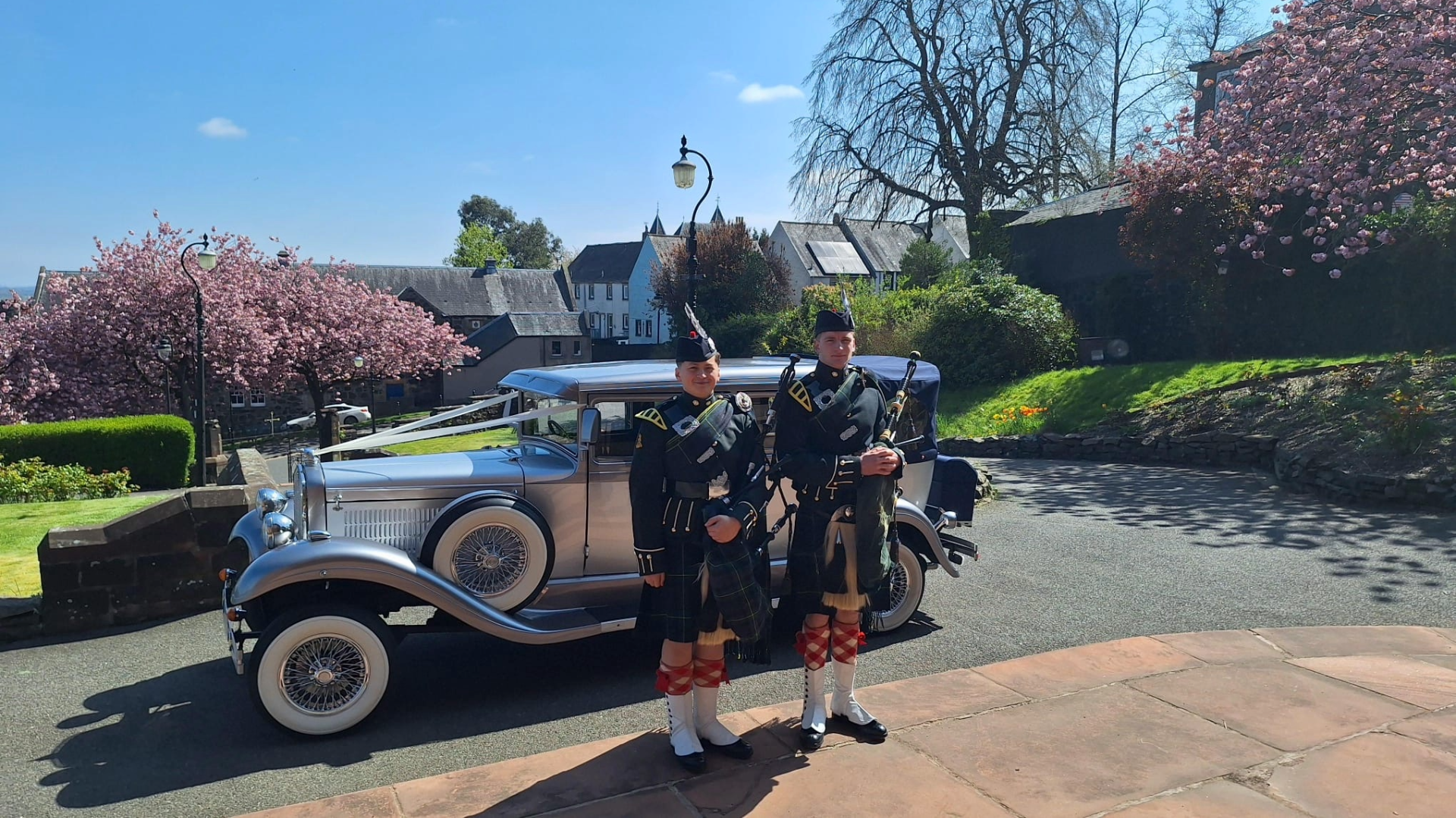 Brandford elite wedding car parked behind bagpipers
