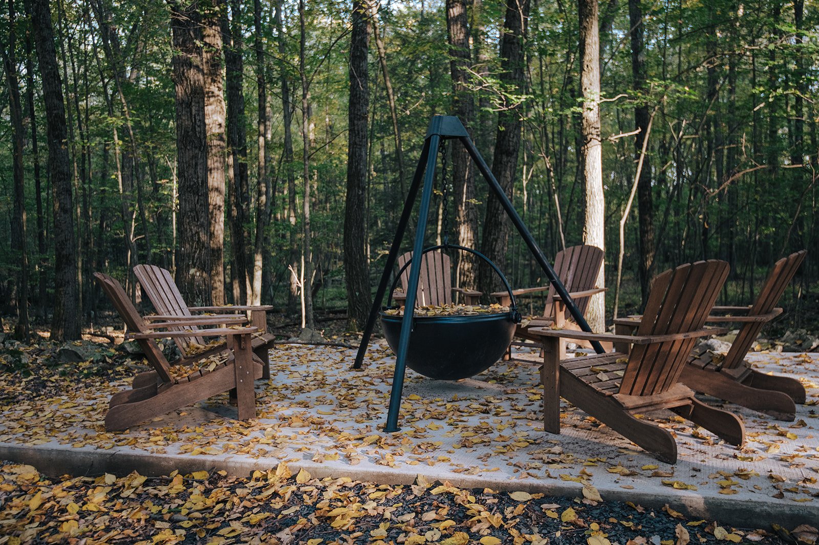 Outdoor wood burning fire cauldron surrounded by cozy Adirondack seating.