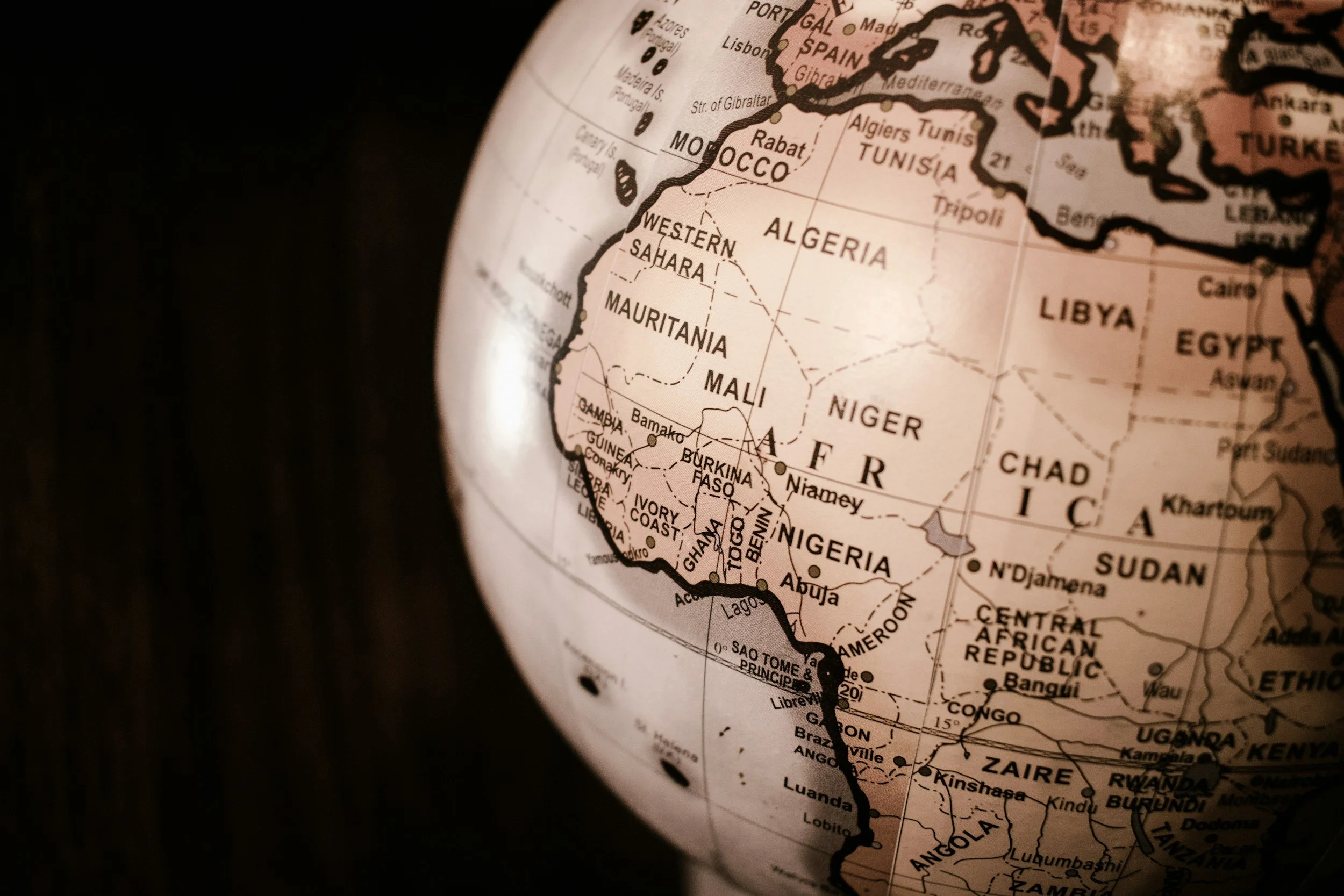 Close-up of a globe showing the continent of Africa with countries such as Nigeria, Ghana, Mali, Algeria, Libya, Egypt, South Africa, and others labeled.