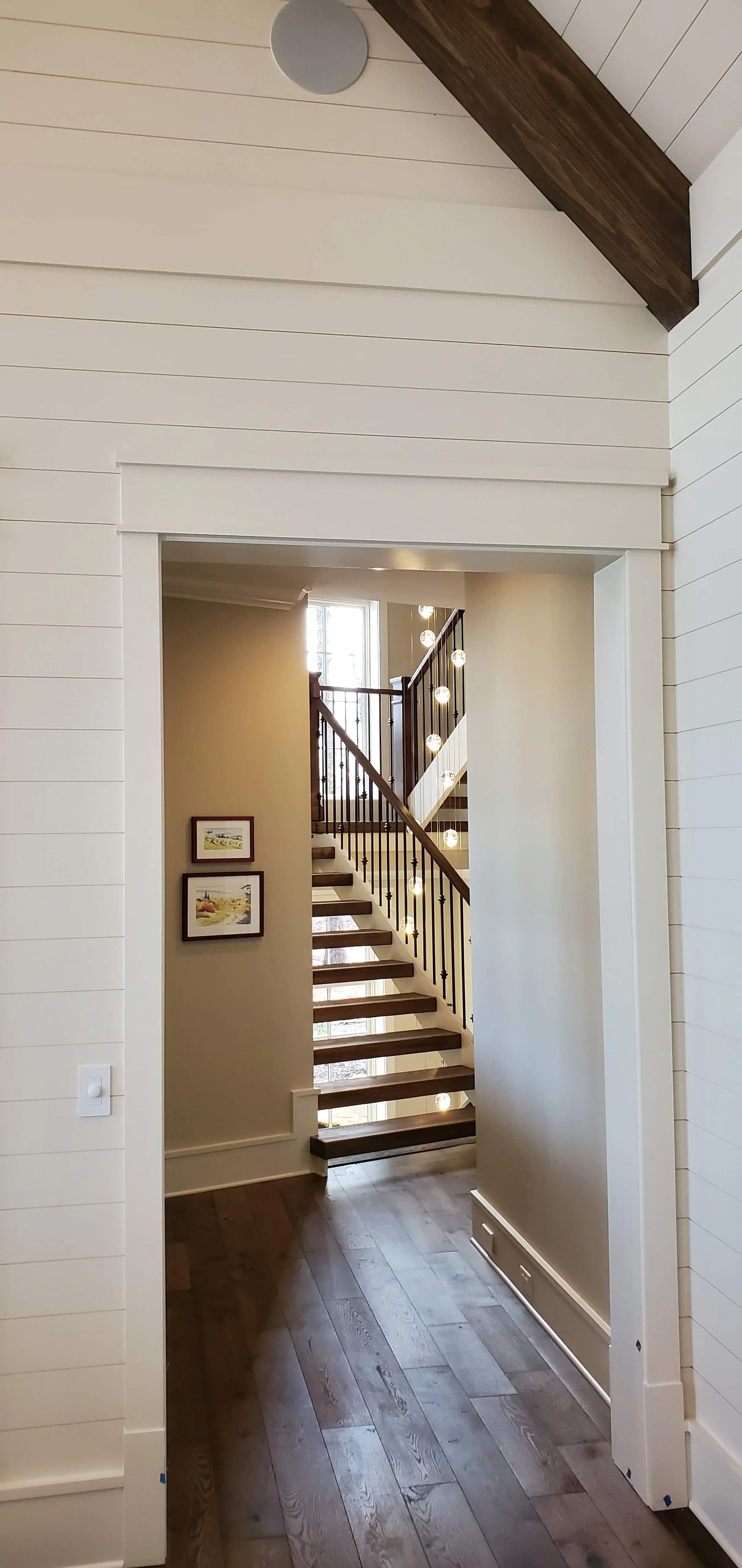 Custom interior staircase with wood trim railing and shiplap walls in Greenville SC