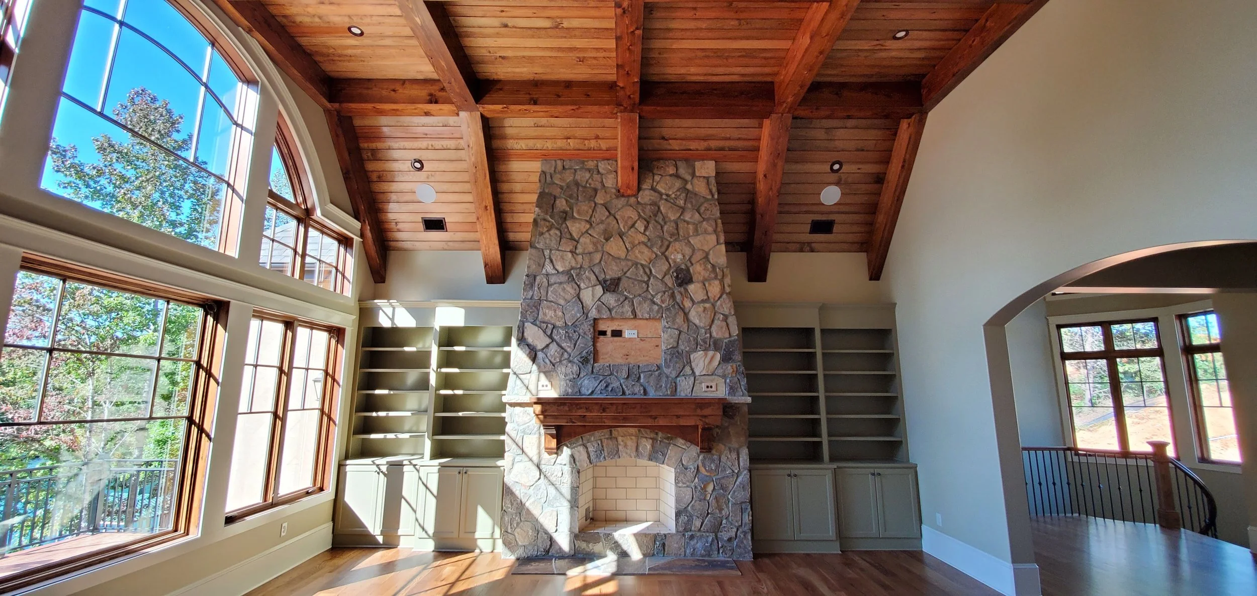 Custom wood ceiling with exposed beams and stone fireplace trim in Greenville SC