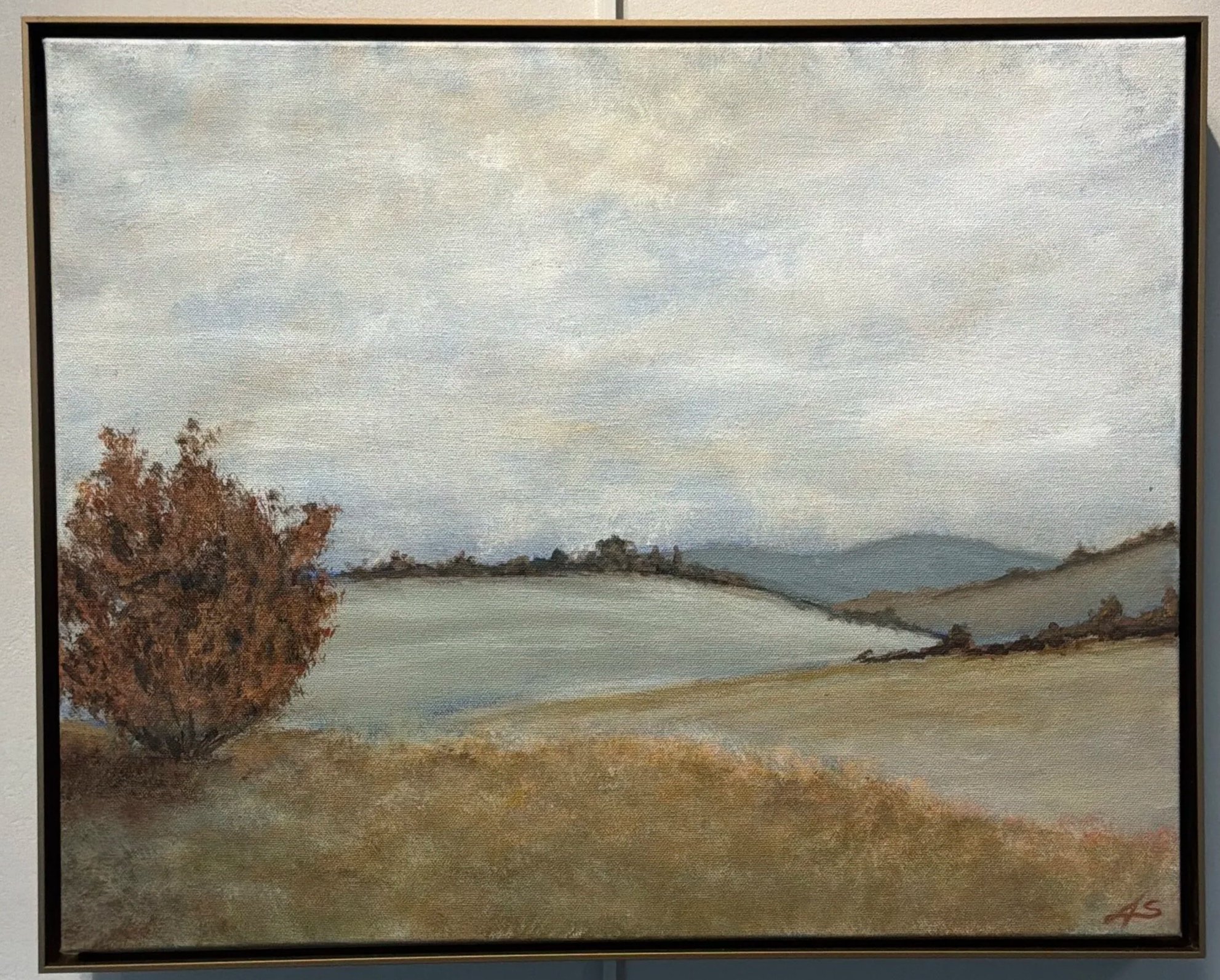 Painting of a landscape featuring a cloudy sky, a single tree with autumn leaves, and rolling hills in the distance.