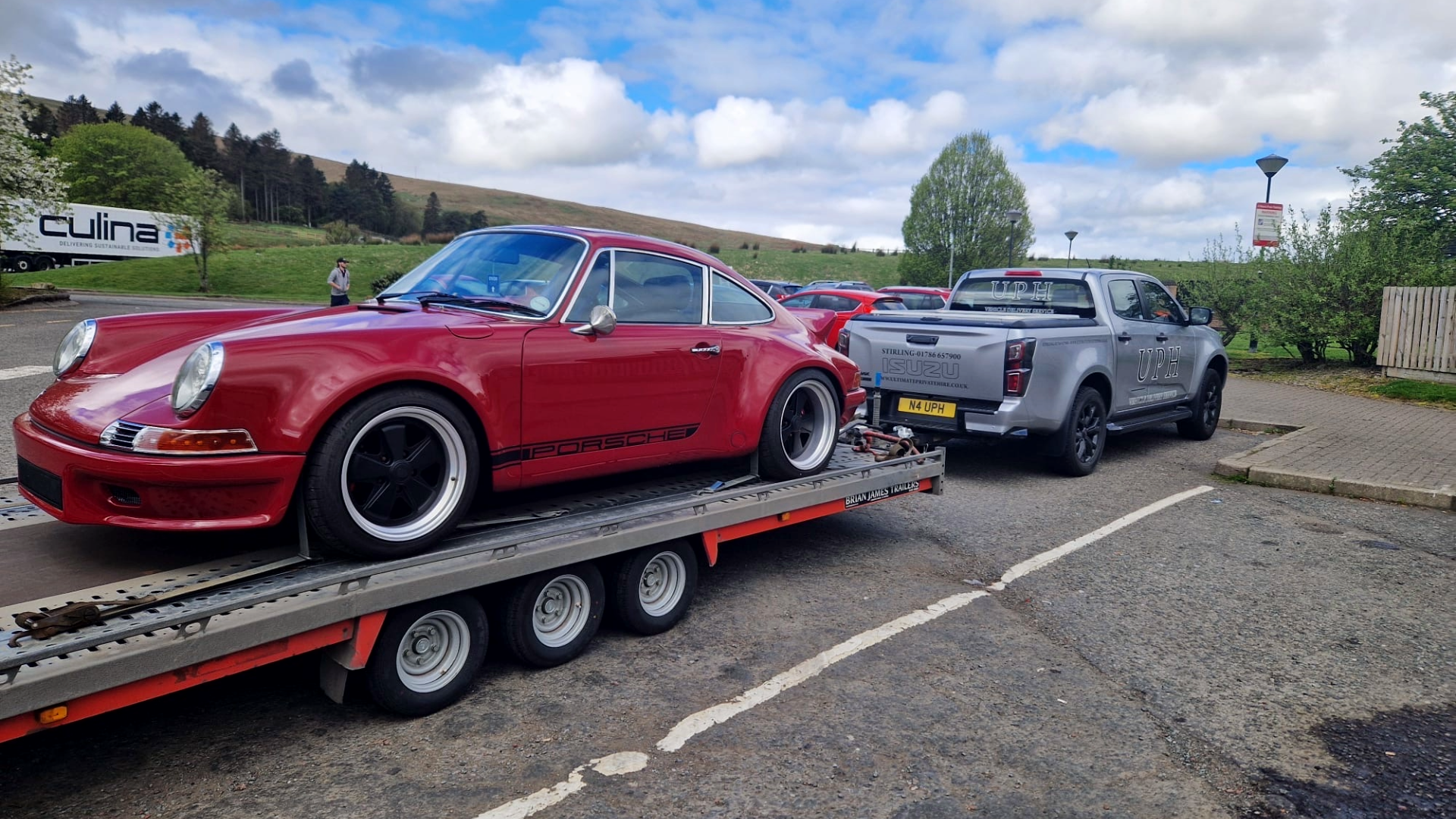 Porsche attached to open trailer - luxury vehicle delivery