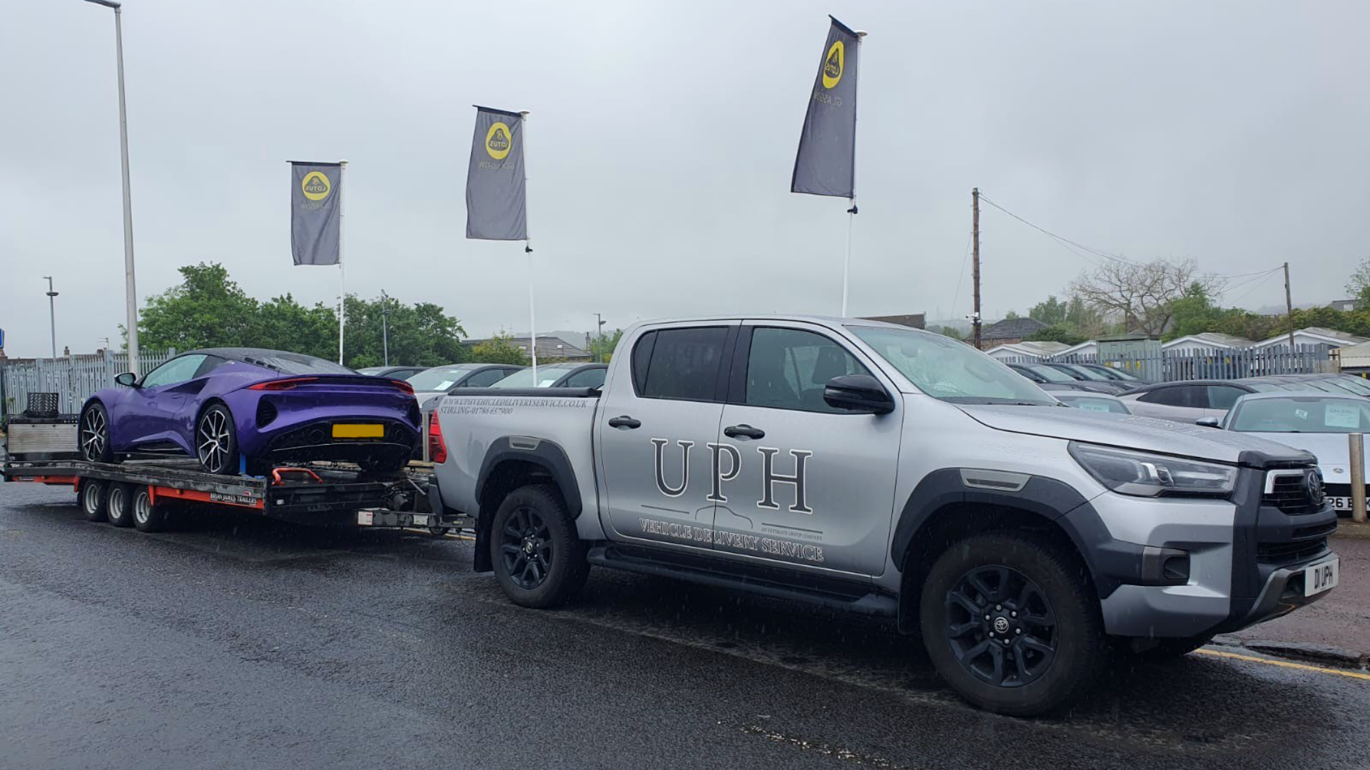 Prestige vehicle on open trailer being delivered to customer