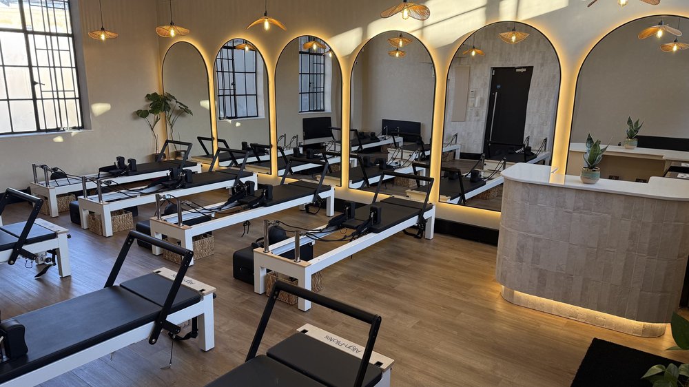A MOTION Reformer studio, with arched mirrors and warm pendant lights