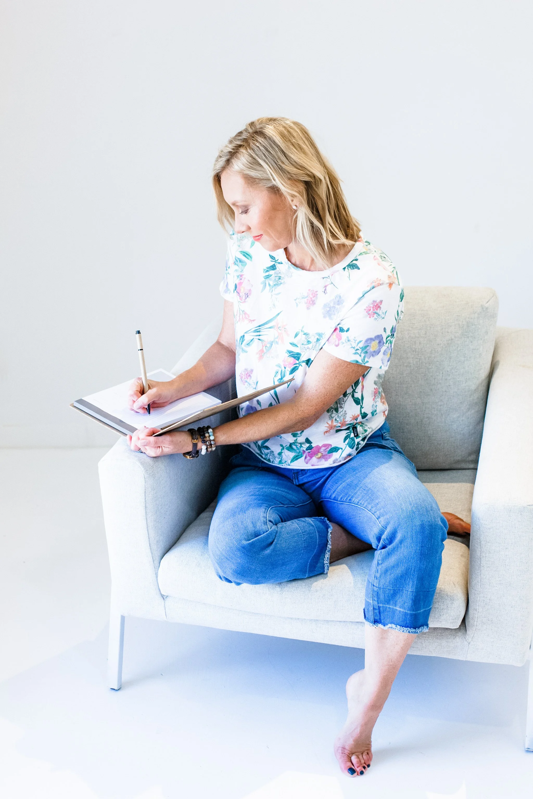 lara ellis web designer on a sofa writing in notebook