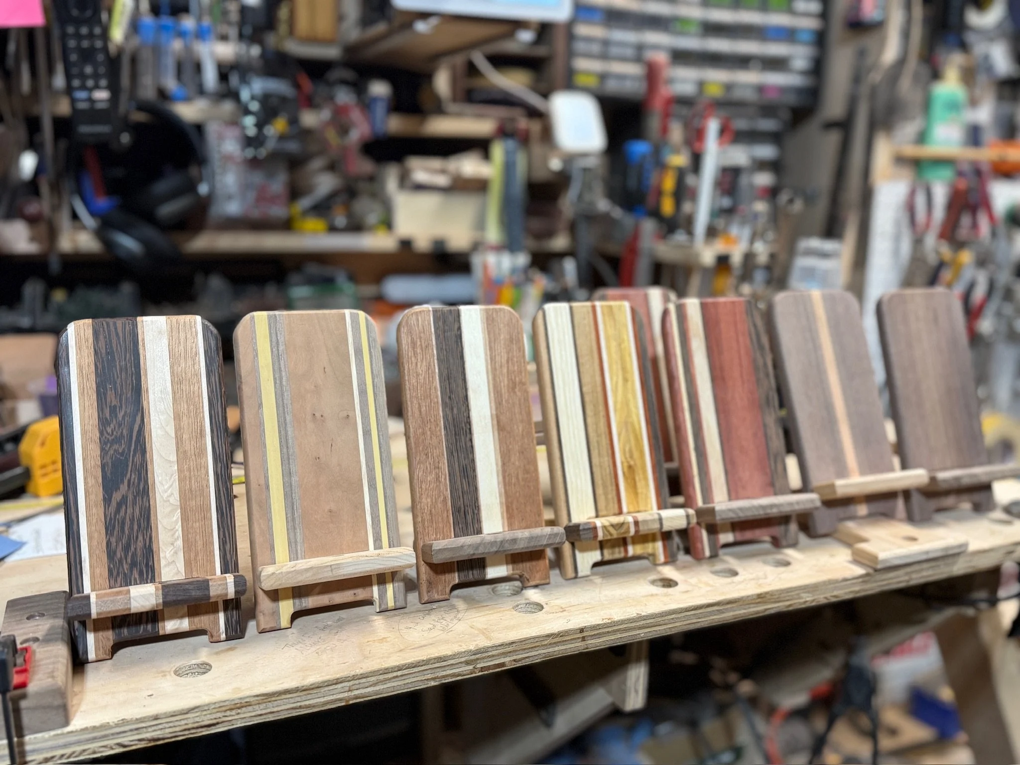An array of currently available Phone Holder designs, made from various hardwood species in differing designs.  This picture was before the finish was applied, which will bring out the colors and richness of the woods tremendously.