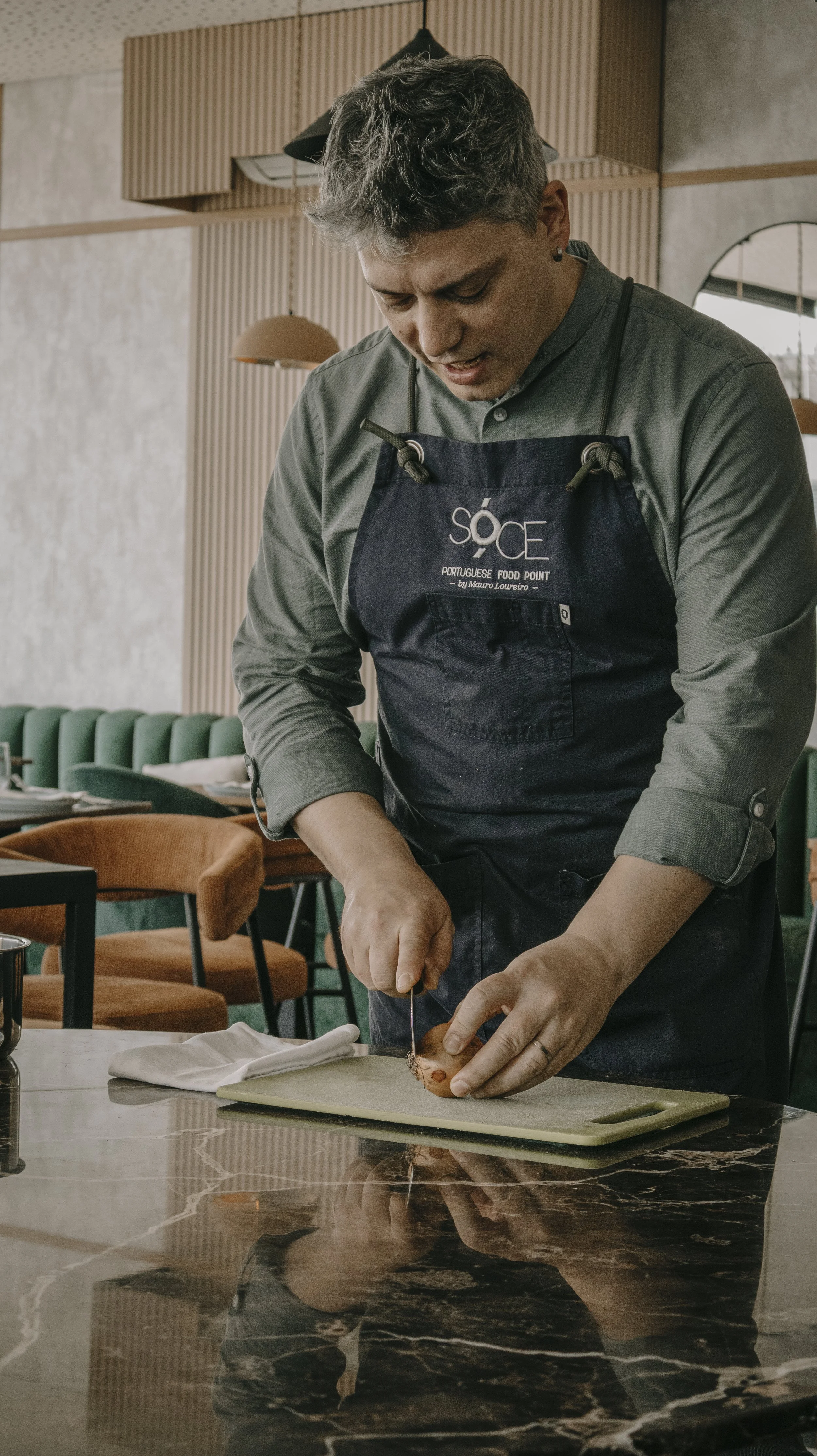 Homem cortando um peixe cru em uma tábua de cortar em um restaurante