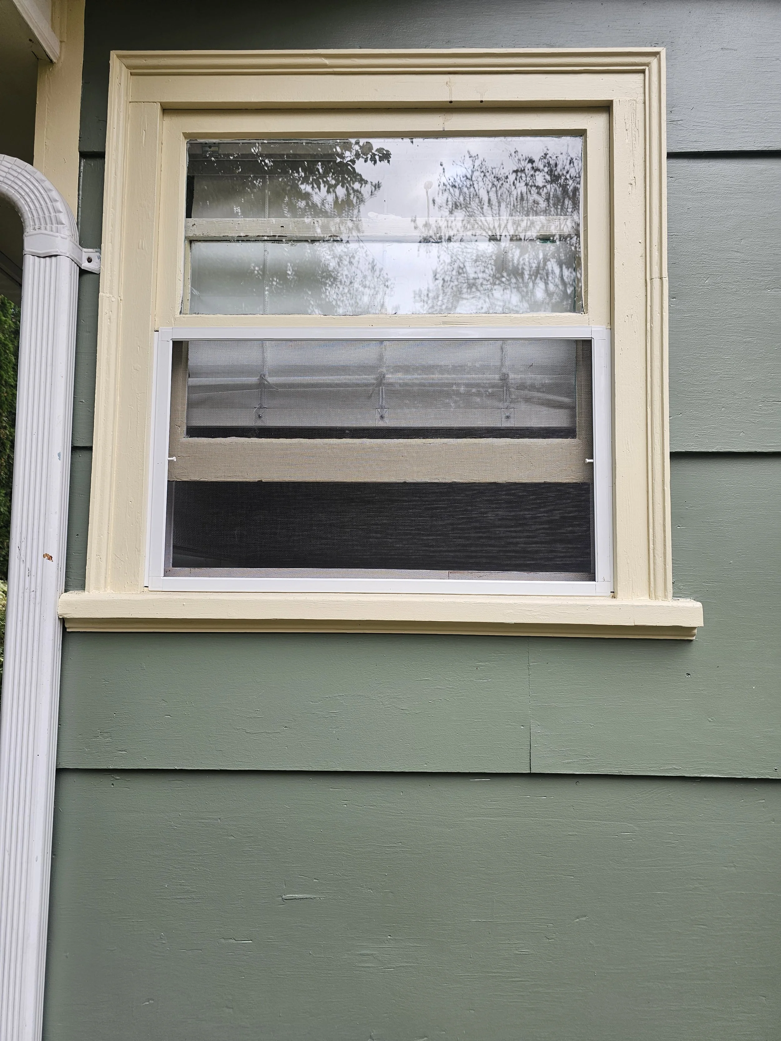 Custom window screen on an old wood frame window