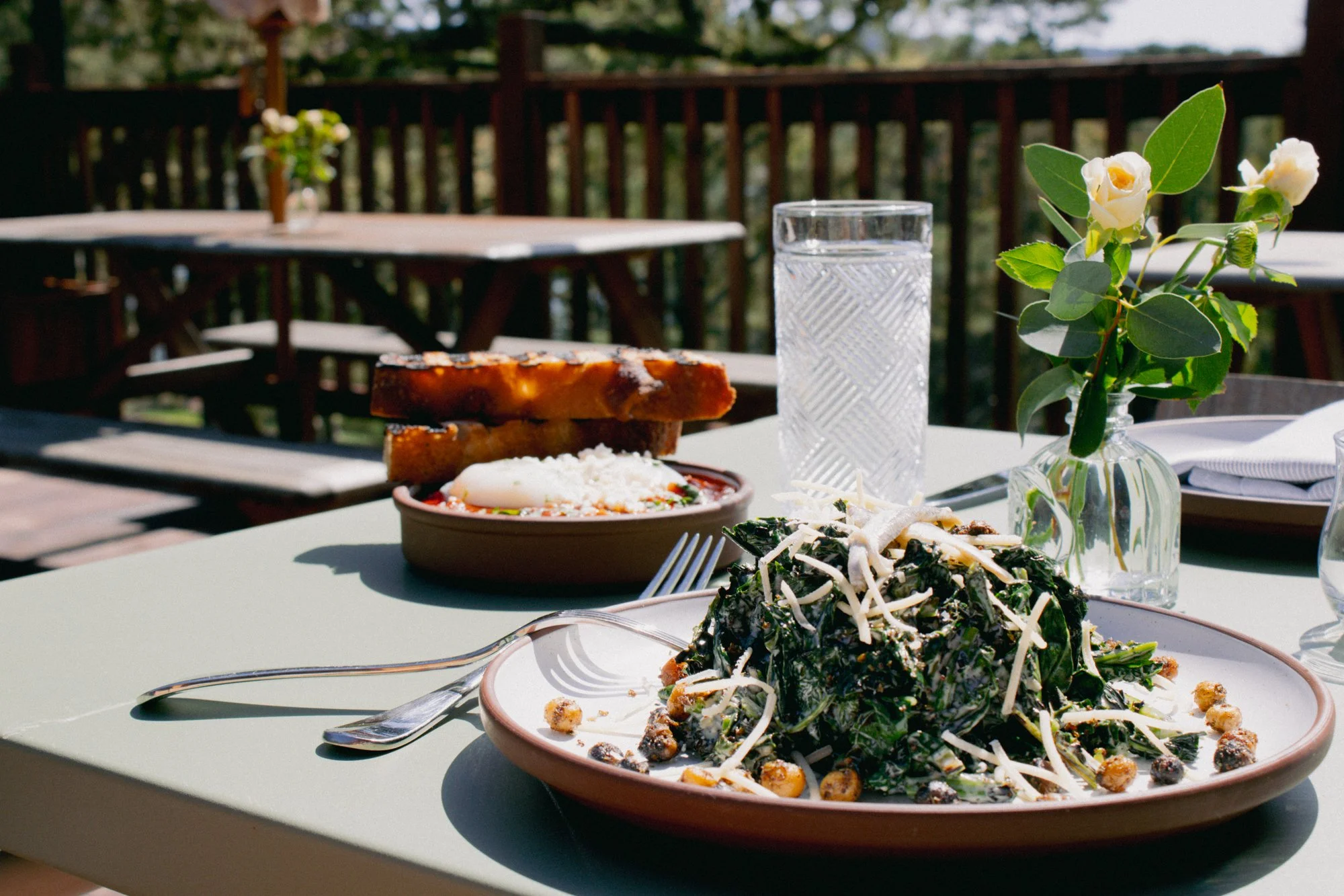 Brunch table spread on patio at Mable's, featuring entrees and flowers