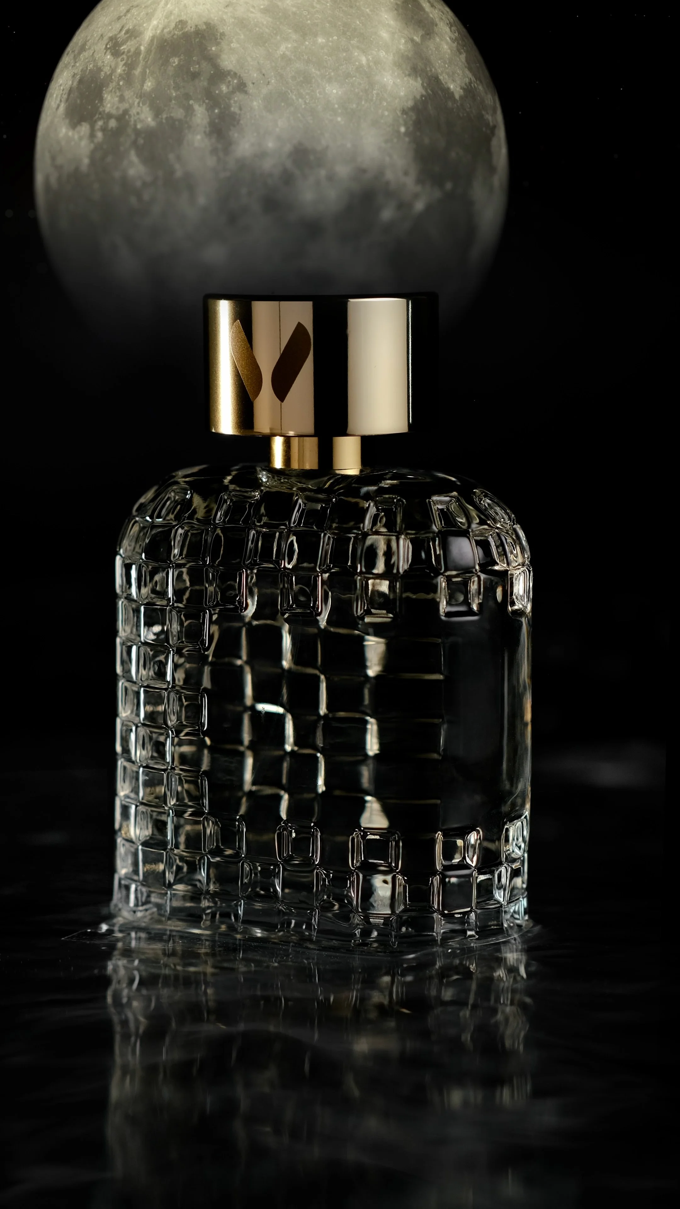 Bouteille de parfum en verre avec un motif en relief, placée devant une image de la lune sur un fond noir