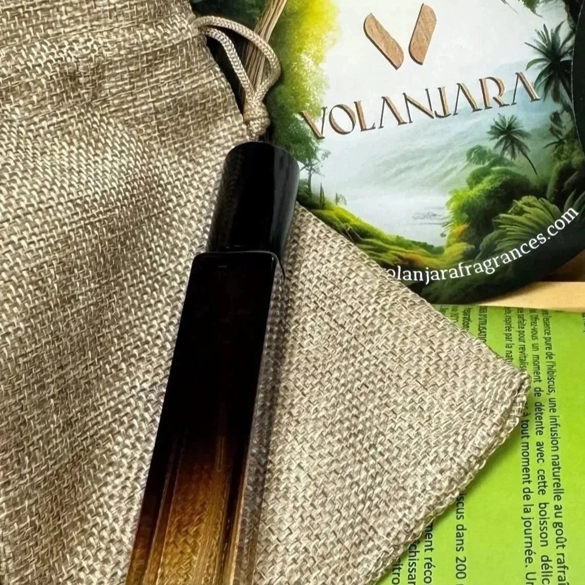 Le format voyage 10ml de l'eau de parfum Volanjara posé sur son pochon en toile de jute accompagné de son flyer Volanjara