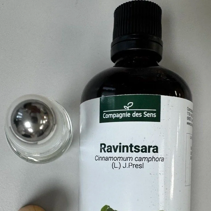 Bouteille d'huile essentielle de Ravintsara (Cinnamomum camphora) de la Compagnie des Sens, vue du dessus, avec un flacon en verre à côté.