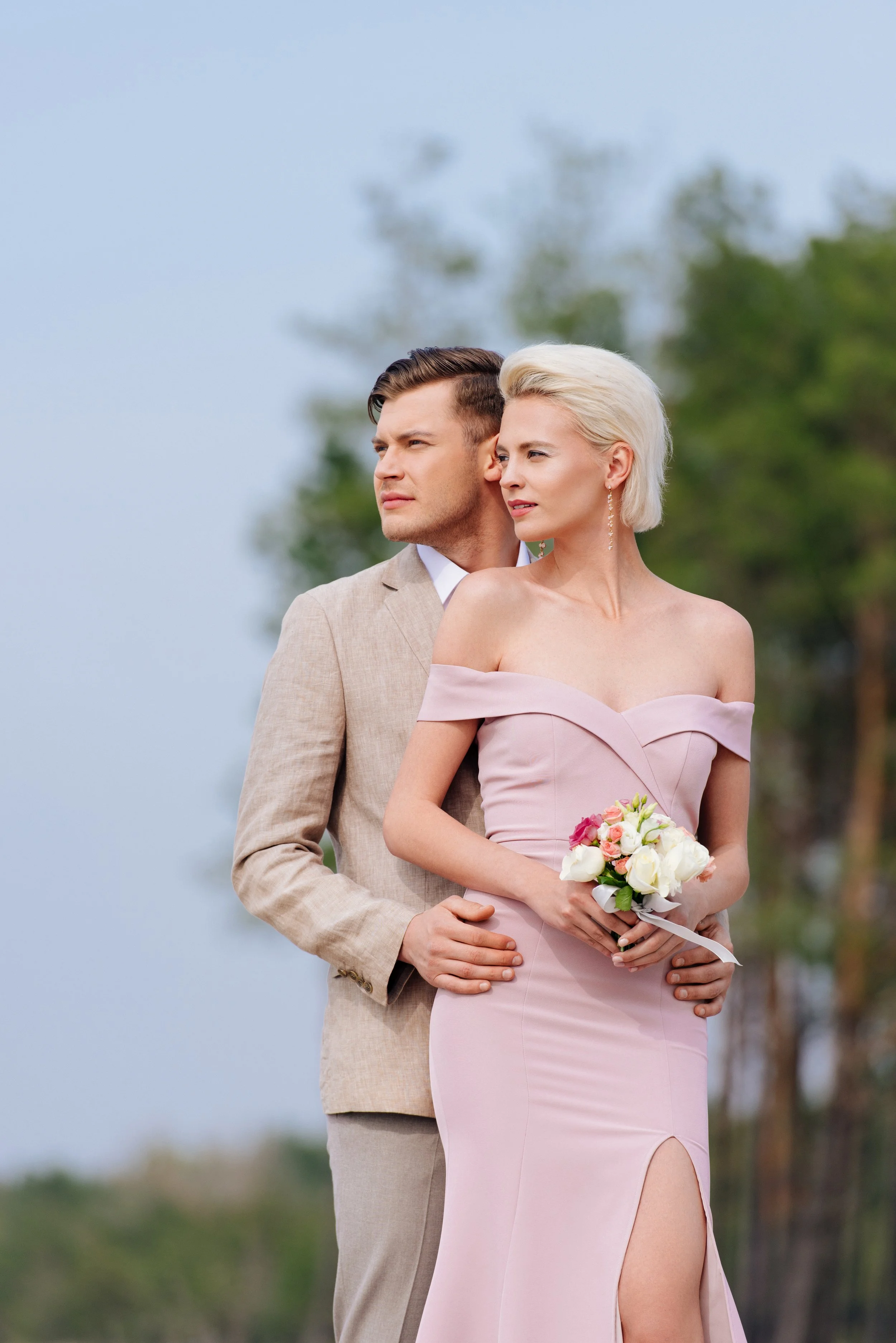 stylish-couple-with-wedding-bouquet-embracing-and-2023-11-27-05-08-28-utc.jpg