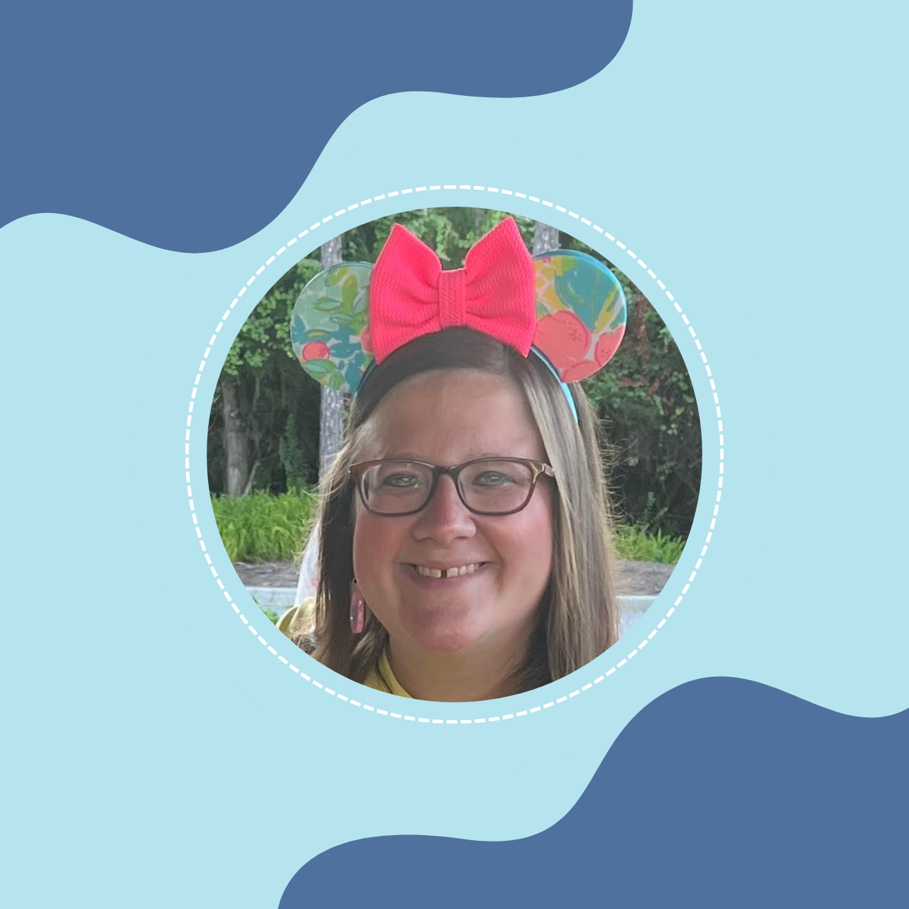 A woman with glasses smiling outdoors, wearing a pink bow headband with colorful Minnie Mouse ears.