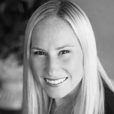 Black and white portrait of a young woman with long straight hair, smiling.