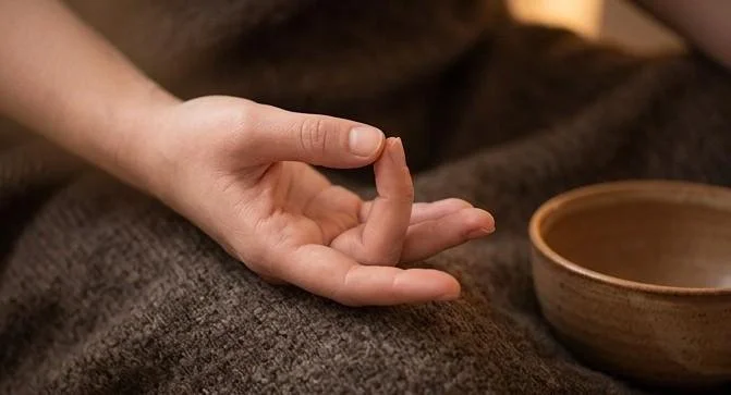 Hand forming Shuni Mudra to calm a scattered, Vata-dominant mind