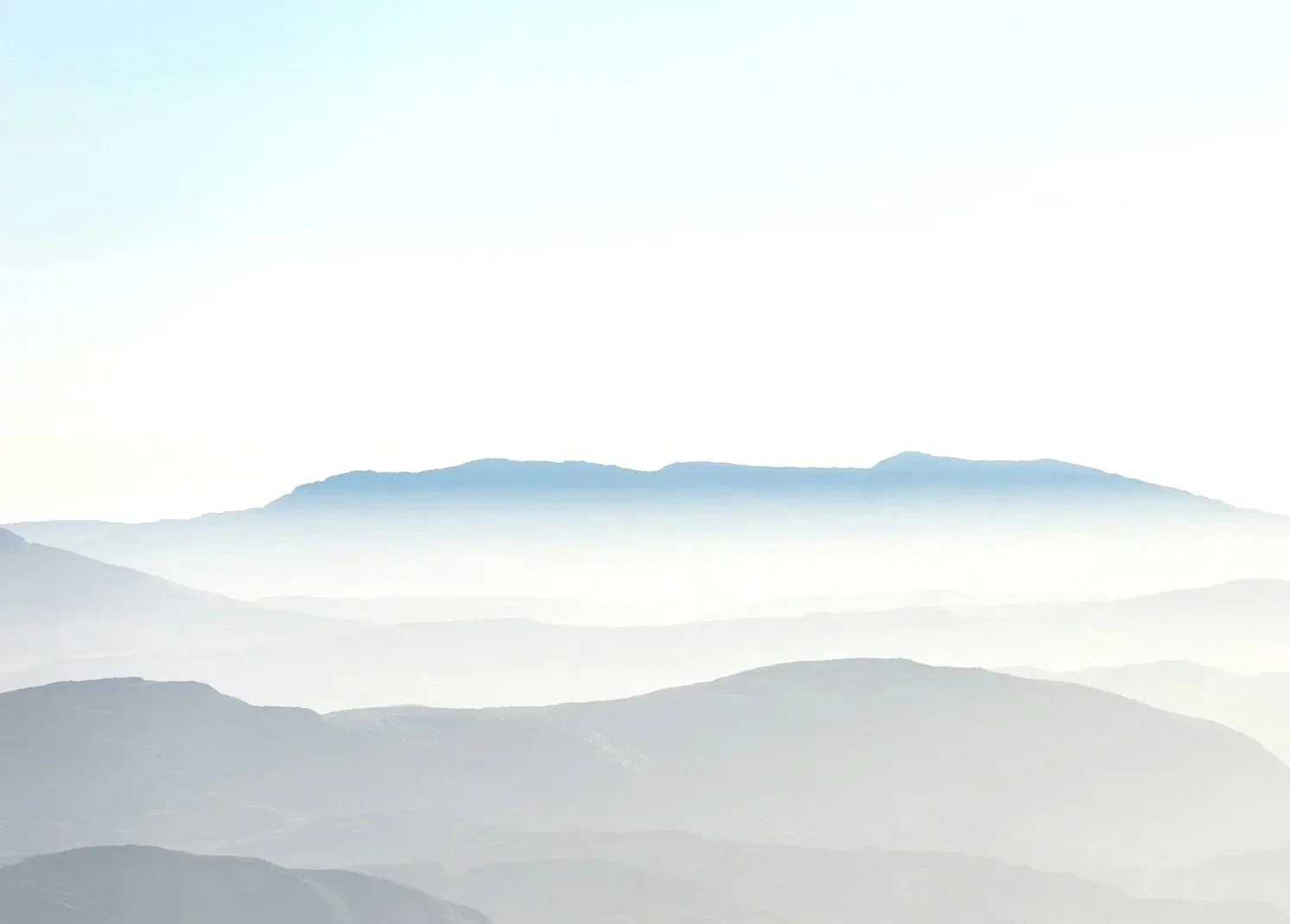 Layers of blue-gray mountains fading into the distance with a light sky above.