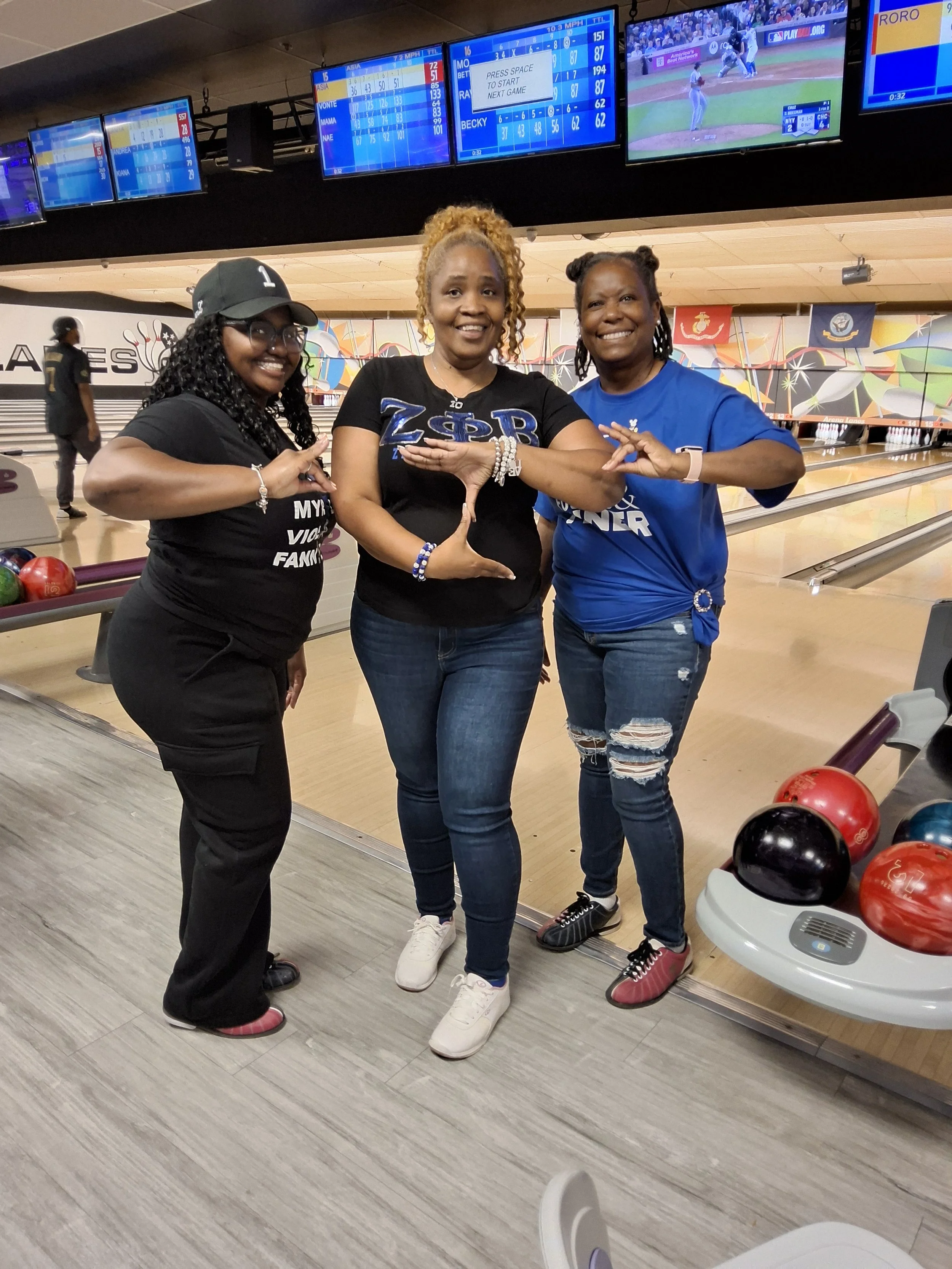 Three women posing near the bowling lanes at BPEFI’s 2026 Bowling for Scholars fundraising event.