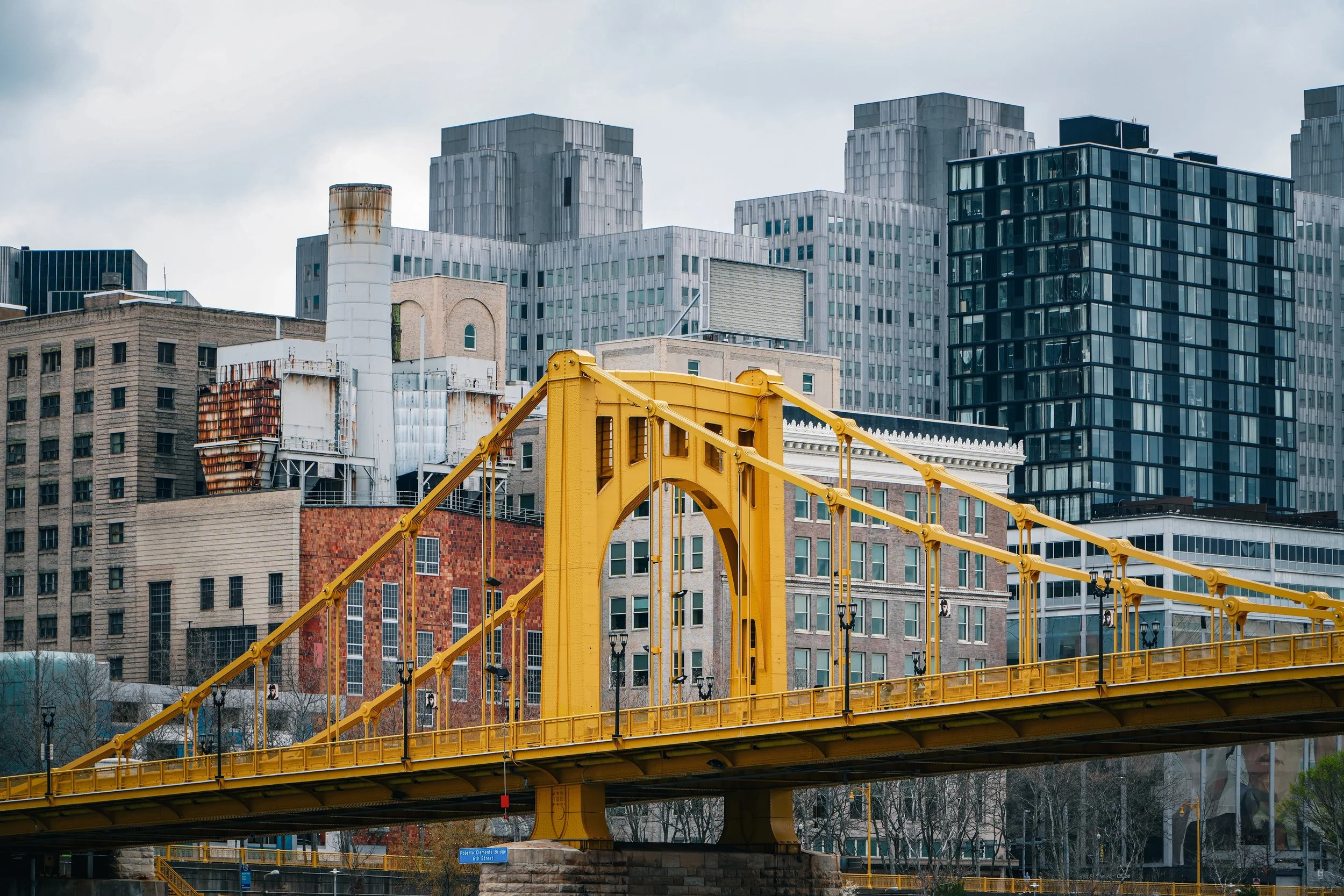 A yellow bridge with city buildings in the background
