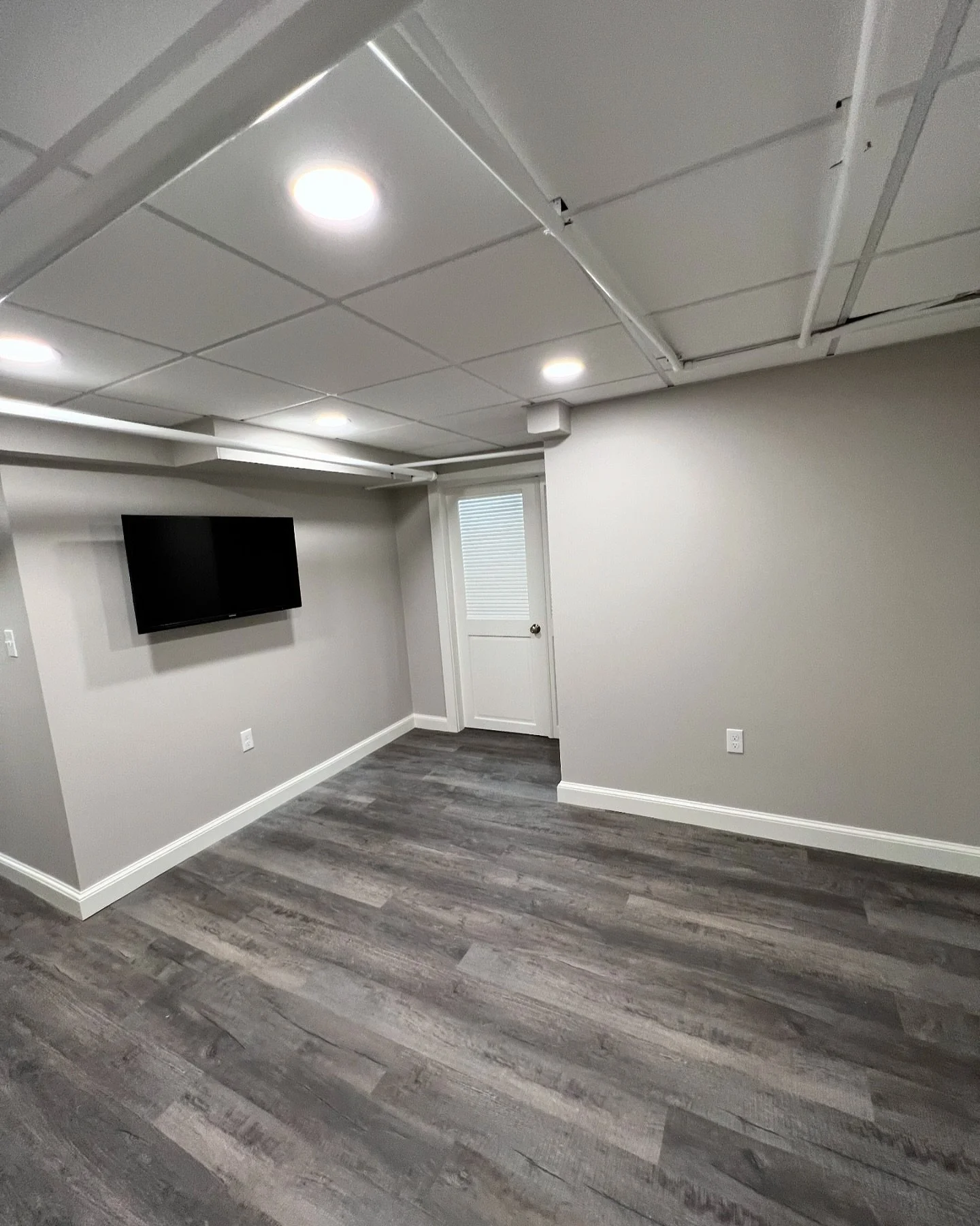 Transformed a previously underused basement into a functional and inviting space. We installed soffits for easier maintenance and to maximize ceiling height, giving the room a more open feel. 

The laundry area was reorganized with hidden machinery f