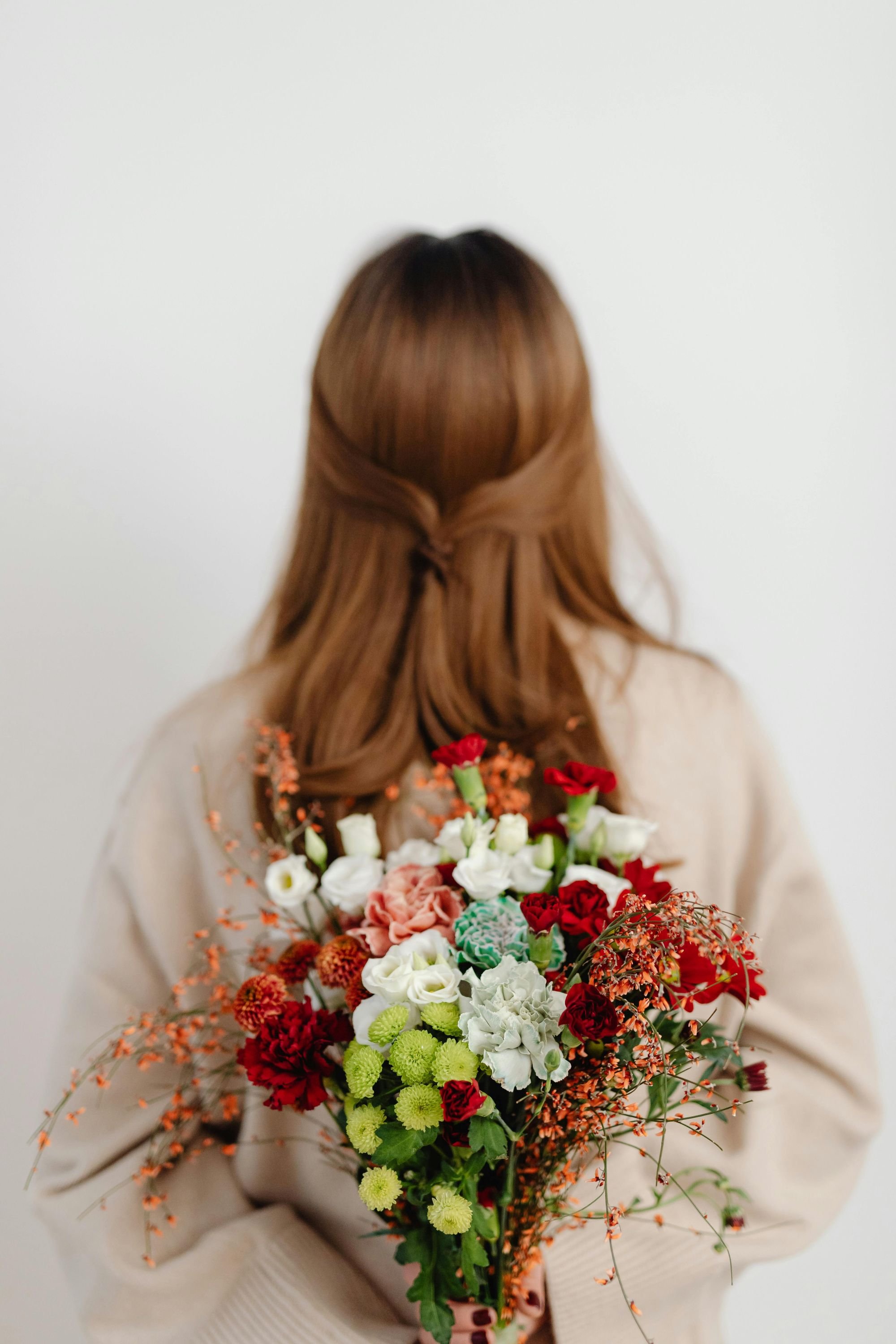 Wedding florist with bridal bouquet before her back