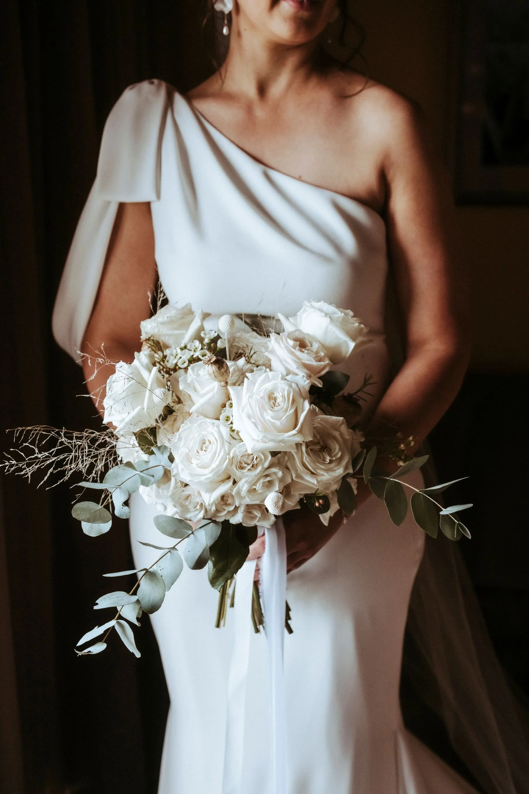 A bride holding beautiful flowers and getting ready for her wedding ceremony
