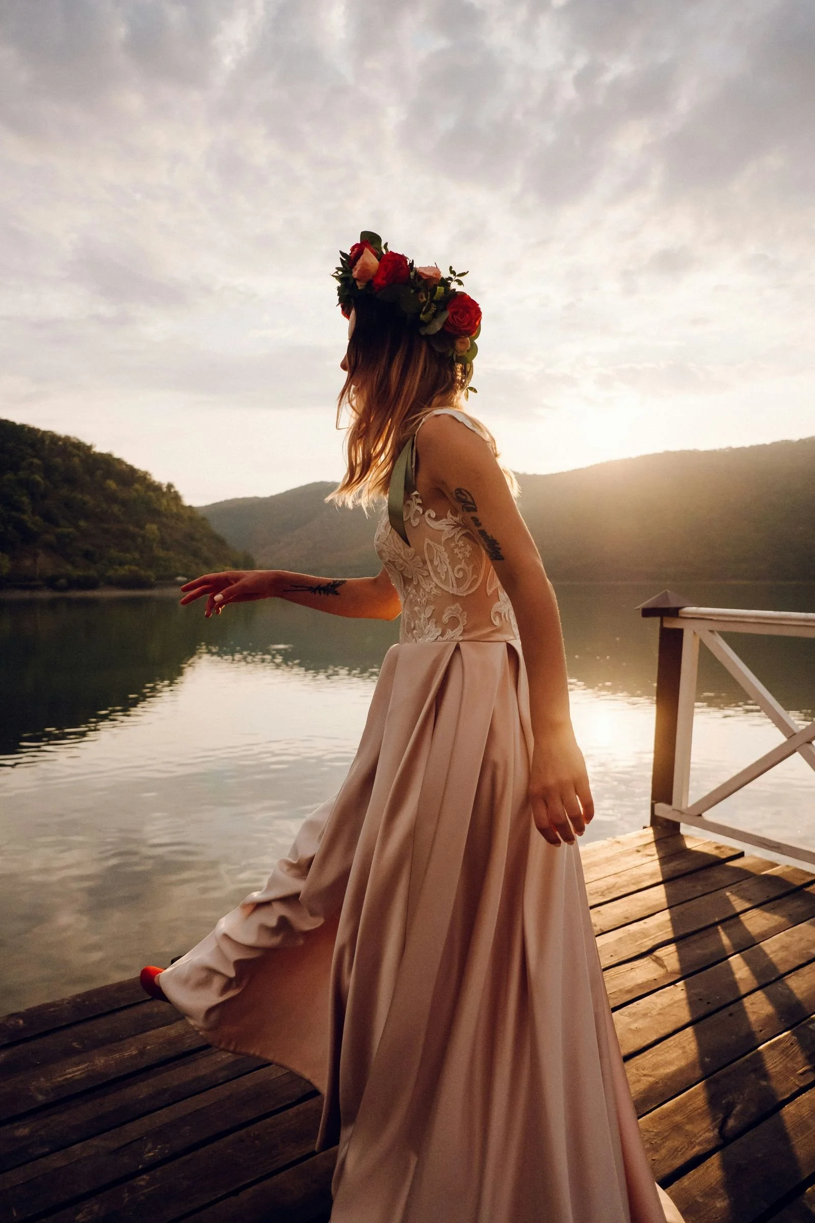 Bride in a beautiful pink wedding dress in front of a lake