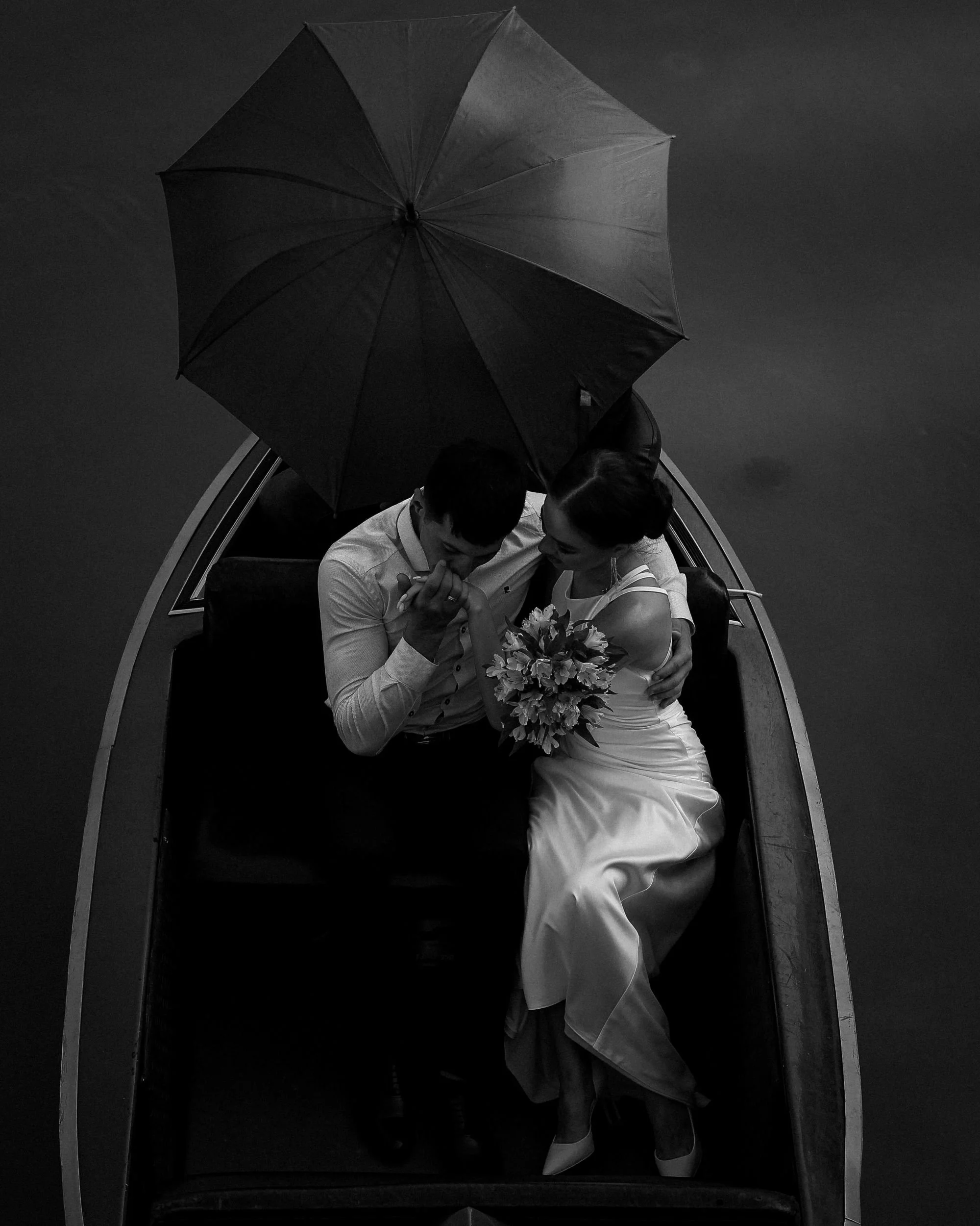 Wedding couple in a boat with an umbrella