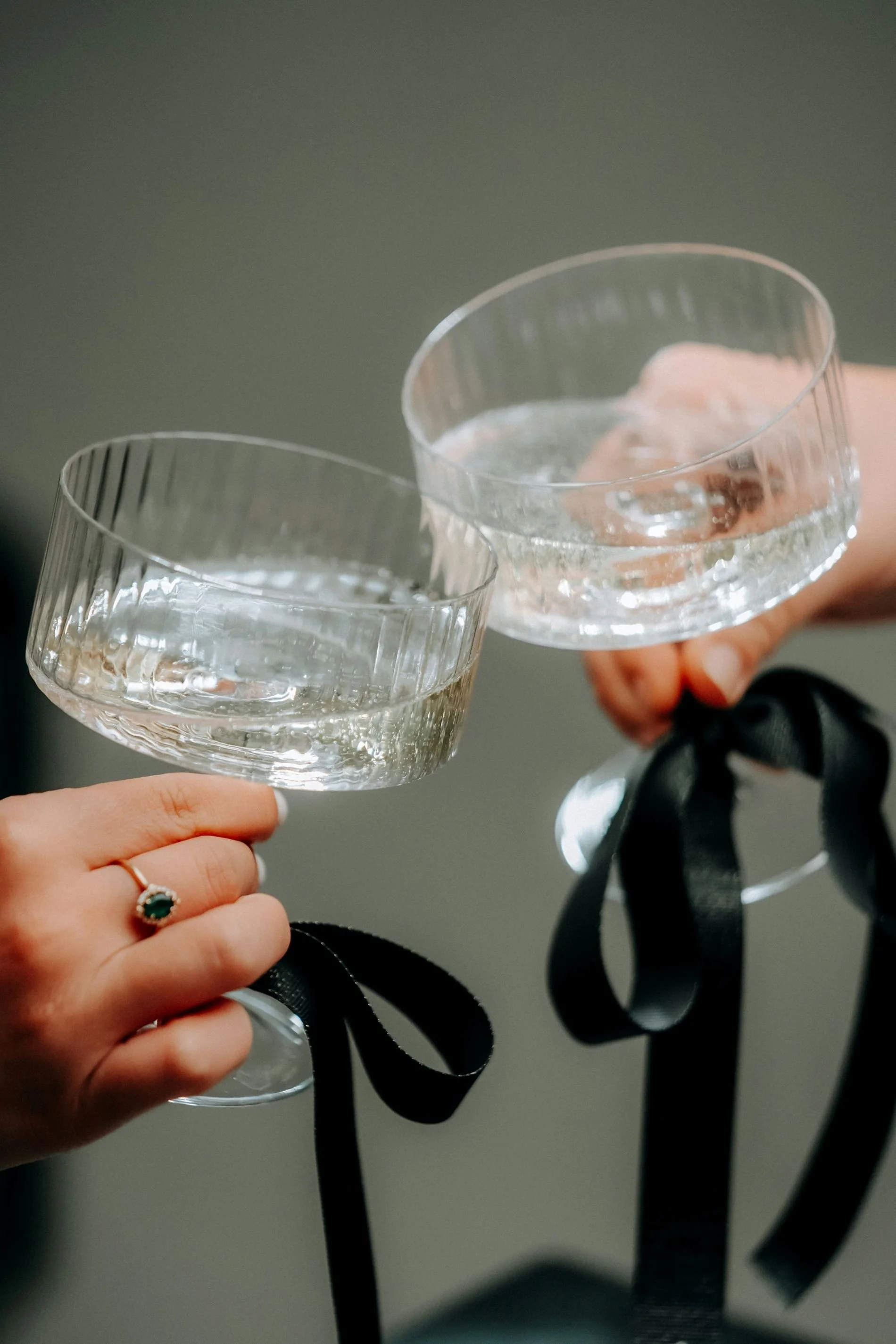 Two martini glasses with black ribbons on the stem