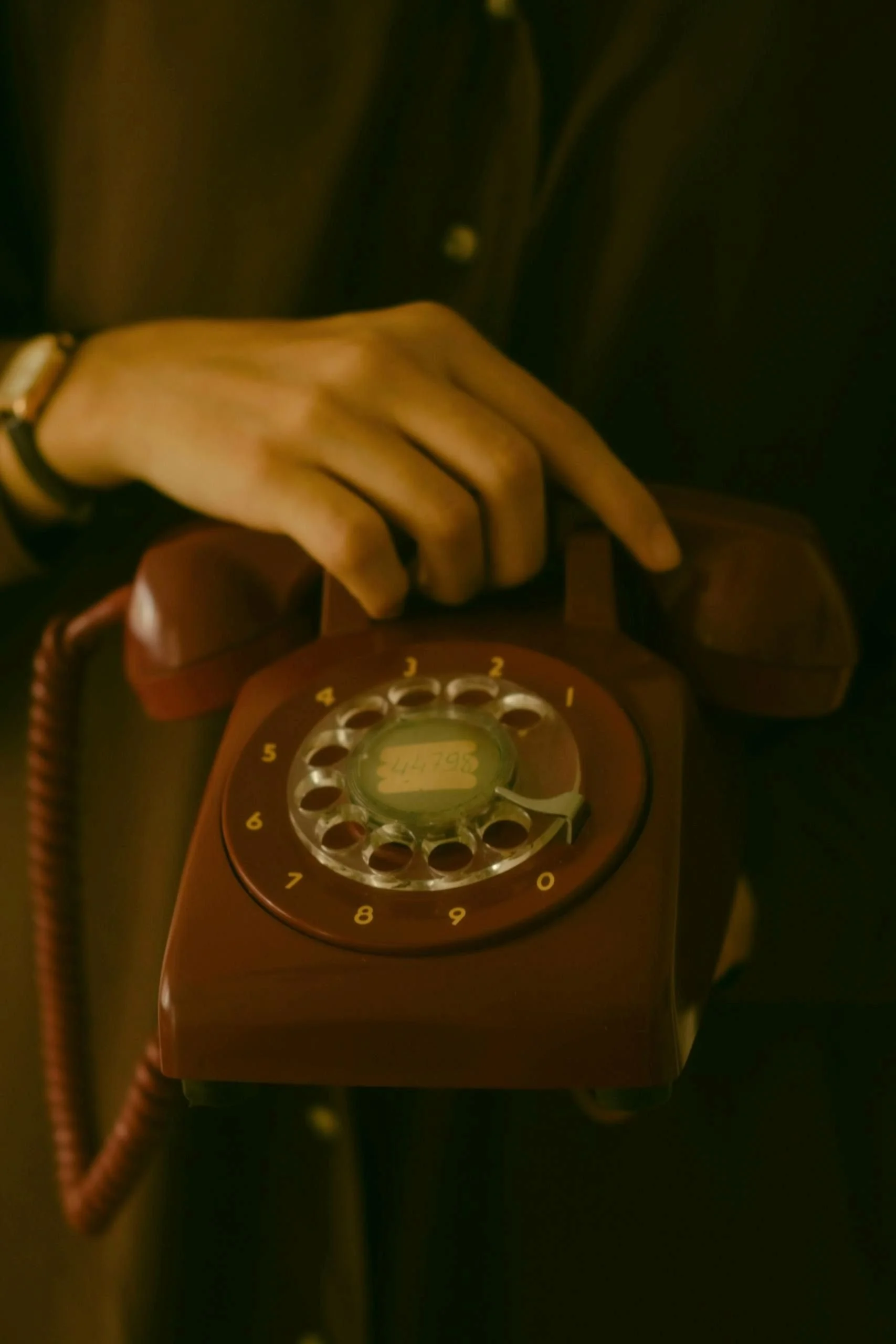 A woman holding a maroon retro phone