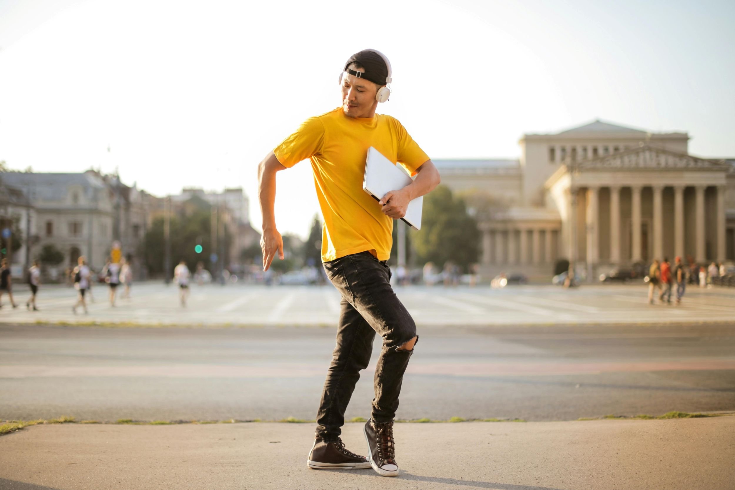 A man dancing in the street with his laptop because Squarespace automatically updates