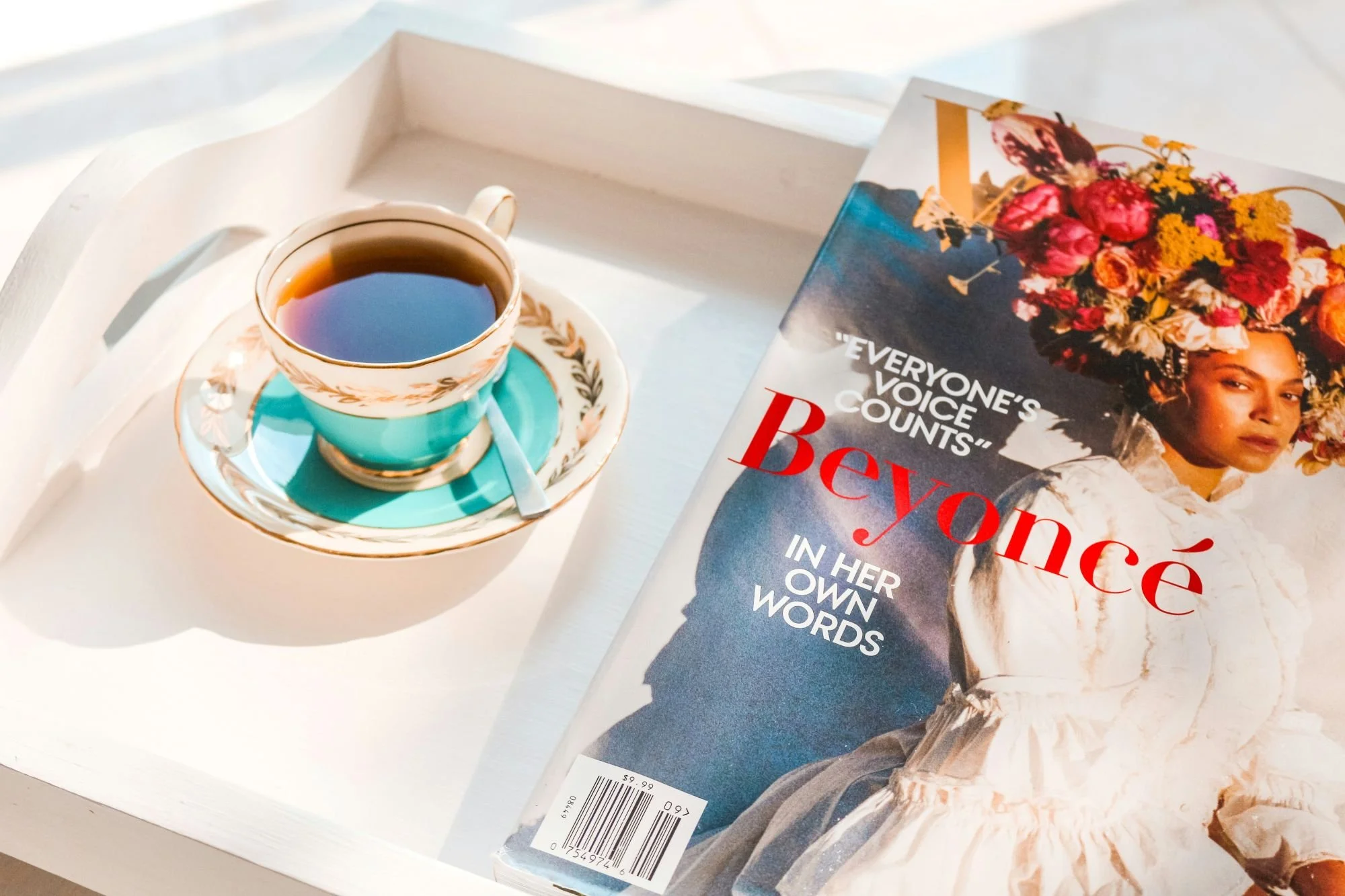 Vouge magazine with Beyonce on the cover sitting next to a black coffee